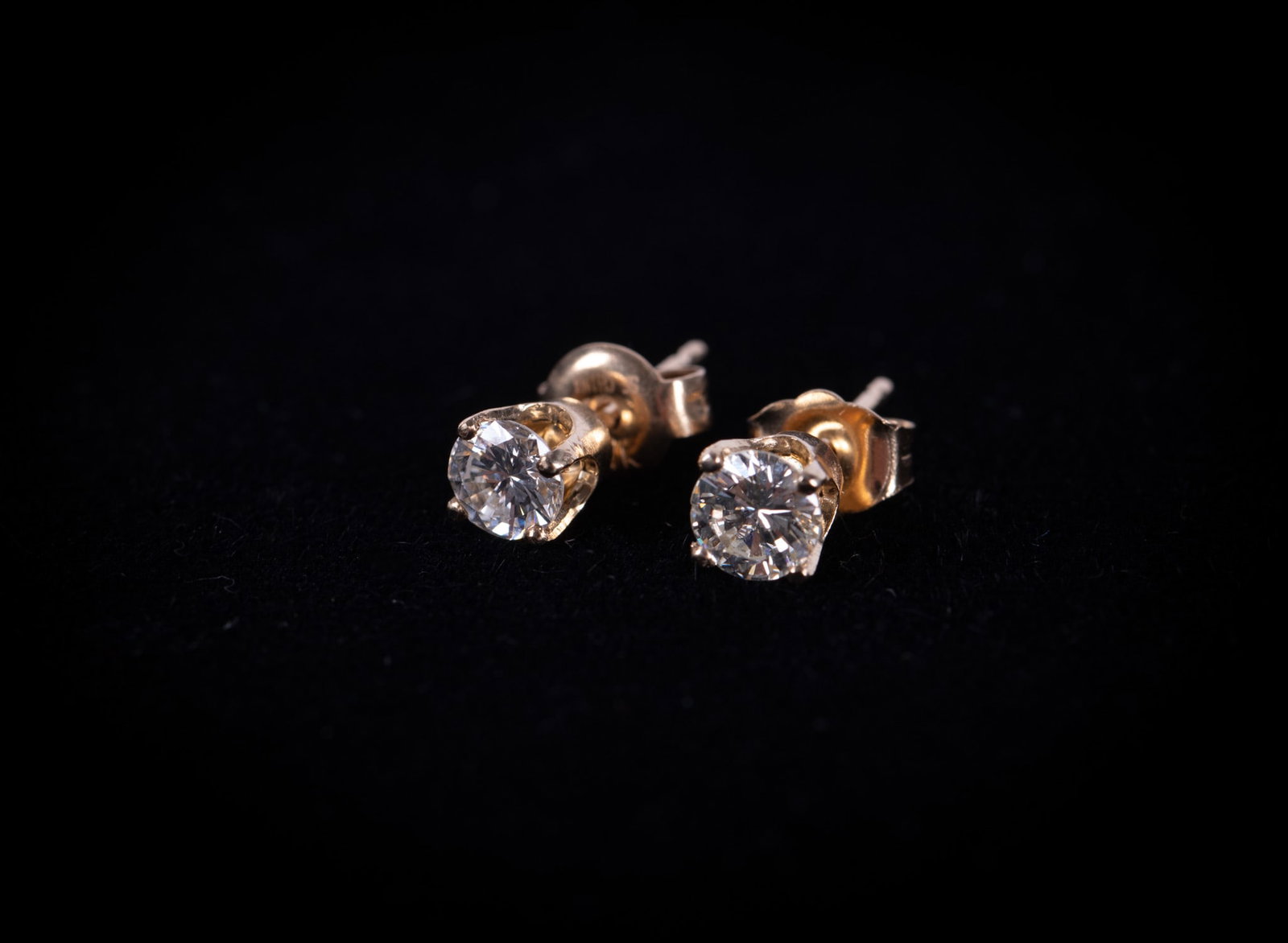 14K Yellow Gold and Diamond Stud Earrings: Ladies earrings marked 14k on back. Each earring has a round brilliant-cut solitaire diamond in four prong basket with a friction back post. Diamond weight is approximately .56ctw. Gross weight: 0.9 g