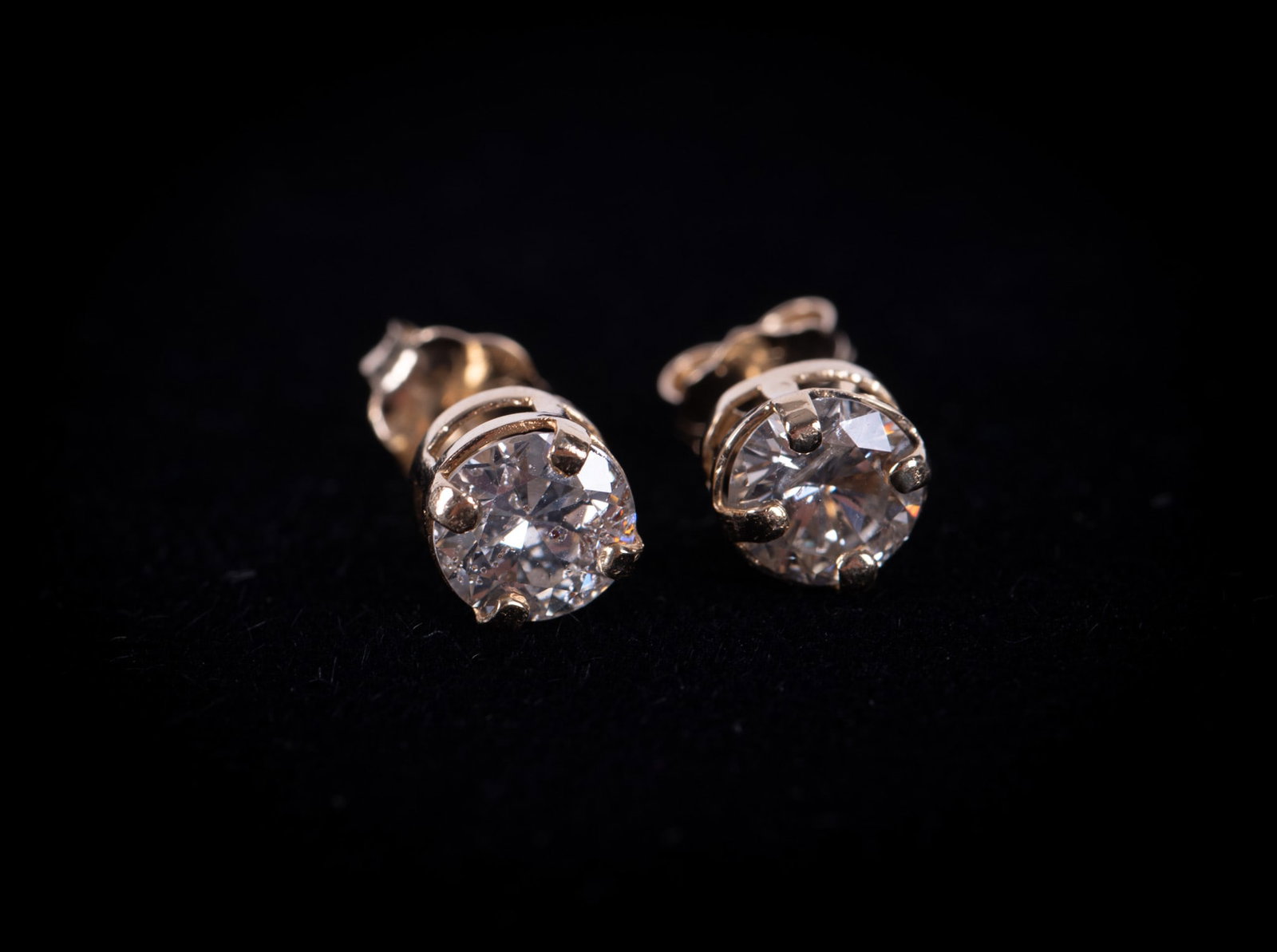 Ladies 14k Yellow Gold and Diamond Studs: ladies 14k earrings with round brilliant cut solitaire diamond in four prong basket setting with friction back post. Marked on post. Diamond weight is approximately 1.12ctw. Gross weight: 1 gram.