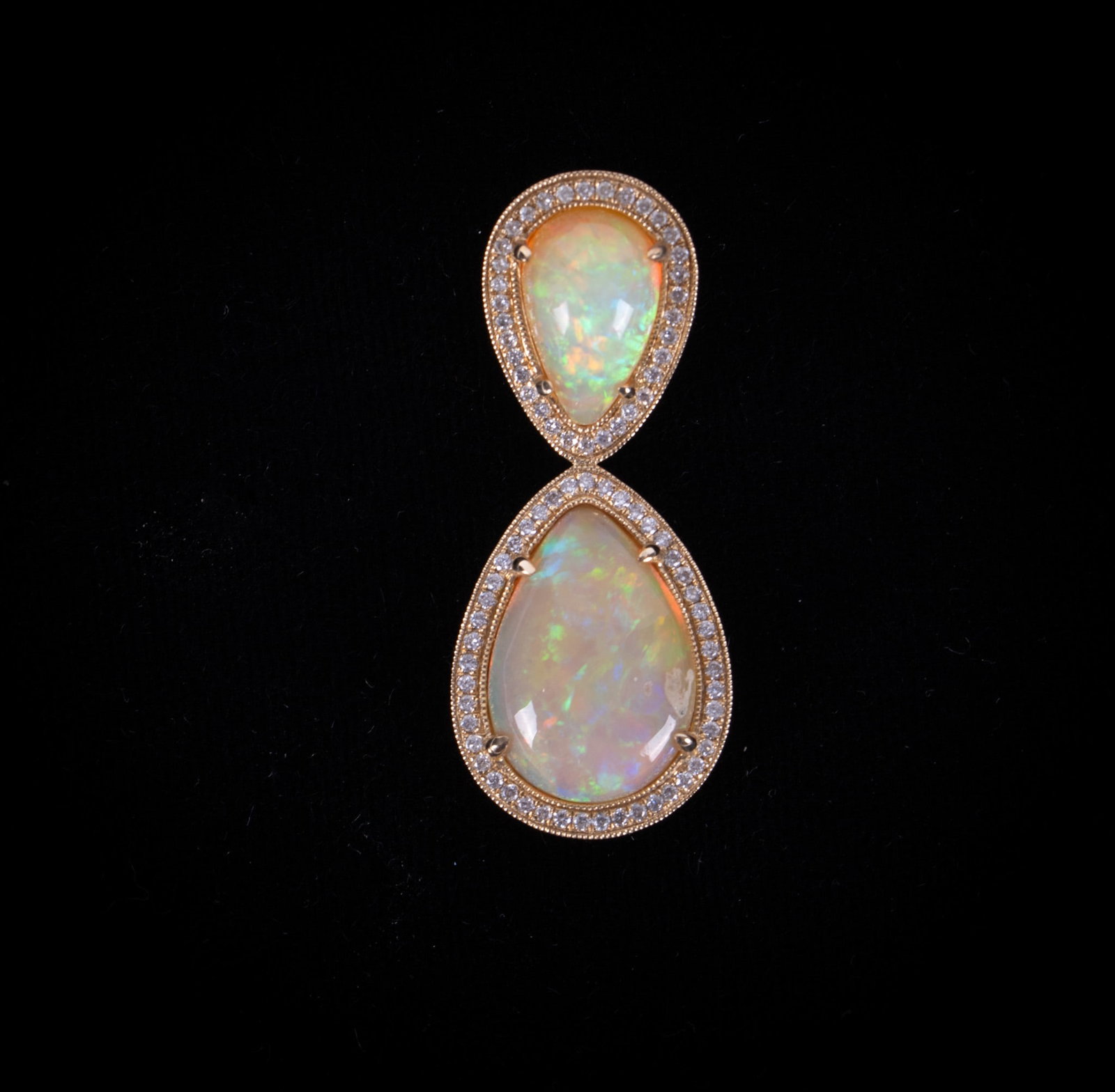 Magnificent Opal & Diamond Pendant set in 14K Yellow Gold: Each of the pear shaped opals have a halo of diamonds surrounding them weighing approximately .80ctw. The smaller opal measures 11.65mm x 7.40mm and the larger measures 15.55mm x 11.40mm. The pendant 
