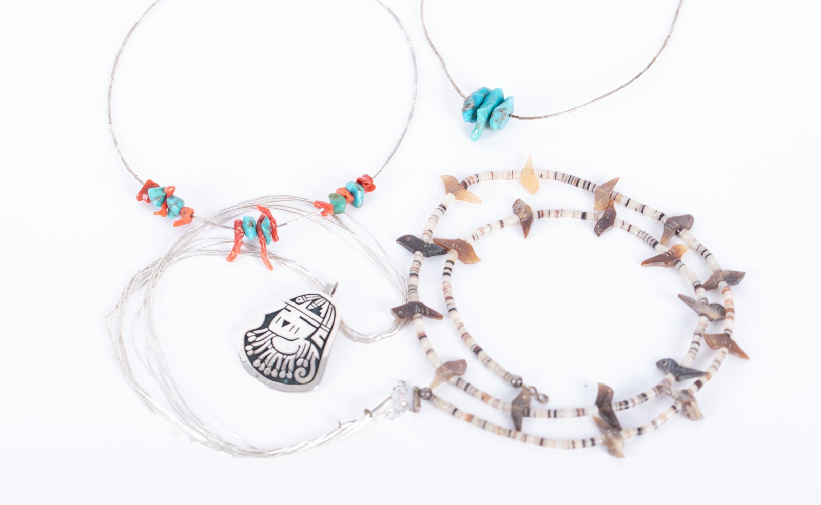 Vintage Native American Necklaces - Four Pieces: First we have a Hopi overlay pendant signed "Puhuhefvaya", the geometric symbol stamped on the left represents a snow cloud, which is the artist's unique Hallmark. The pendant measures 1 7/8 x1 3/4 in