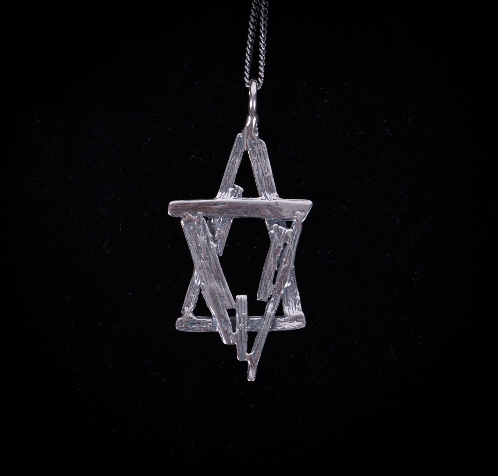 Contemporary Design Sterling Silver Star of David Pendant with Chain: pendant with interlocking triangles and marked Israel 925, pendant 2 x 1 1/8 inches; chain unmarked, length 24 inches. Total weight 0.285 troy ounces
