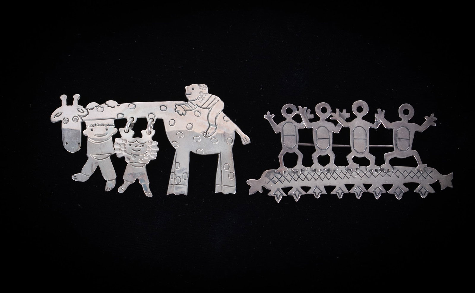 Two Sterling Silver Brooches: The Modernist dancing figures brooch is signed by Phyllis Woods. It is 3 inches long. The quirky giraffe brooch is 2 3/4 inches long. Gross weight is 22.53g.