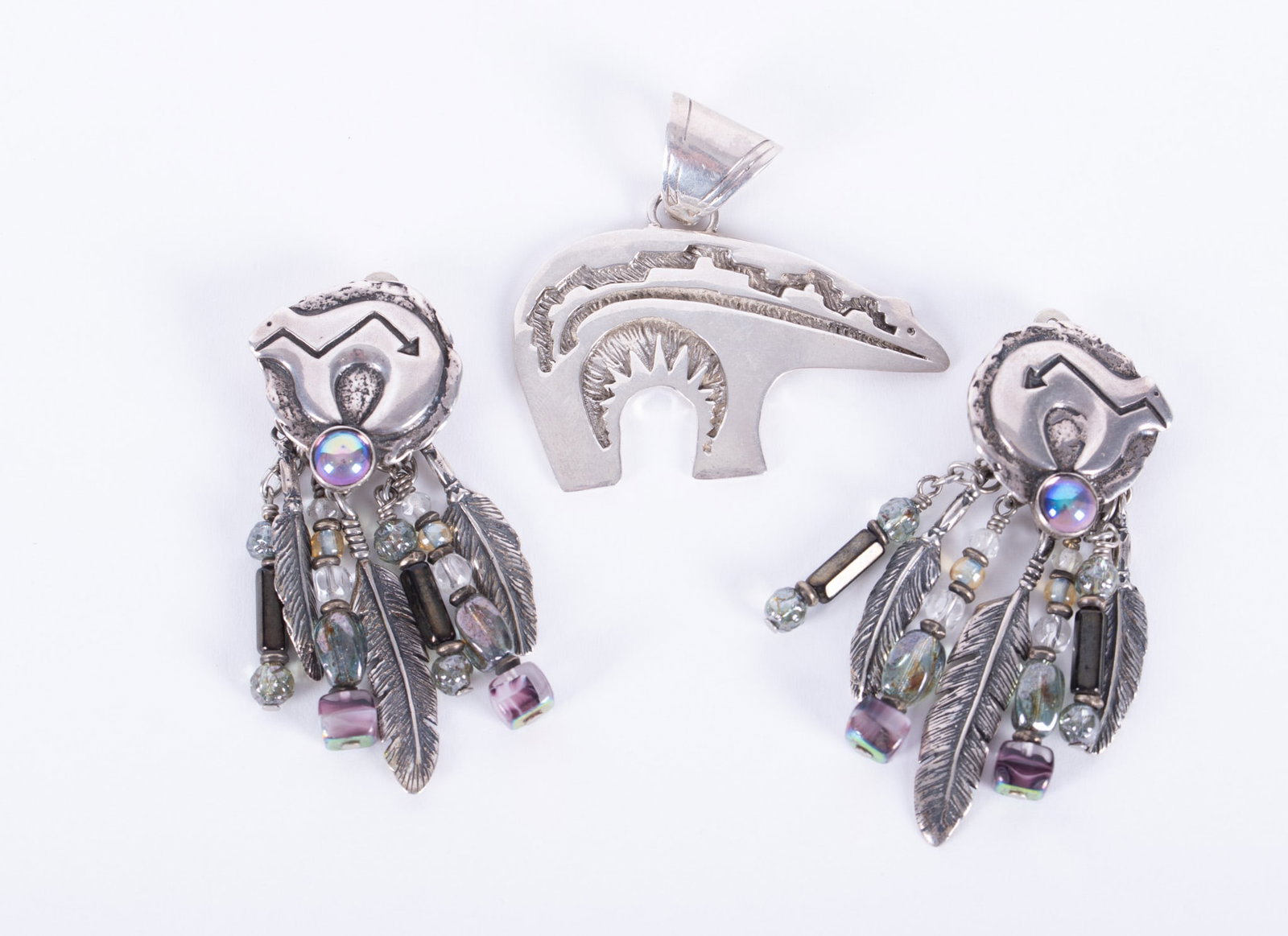 Sterling Bear Pendant and Earrings: The Navajo bear is 2 inches wide and artist signed. The clip back earrings are marked sterling and are adorned with artisan glass beads. They measure 2 3/4 inches long. Weight including stones is