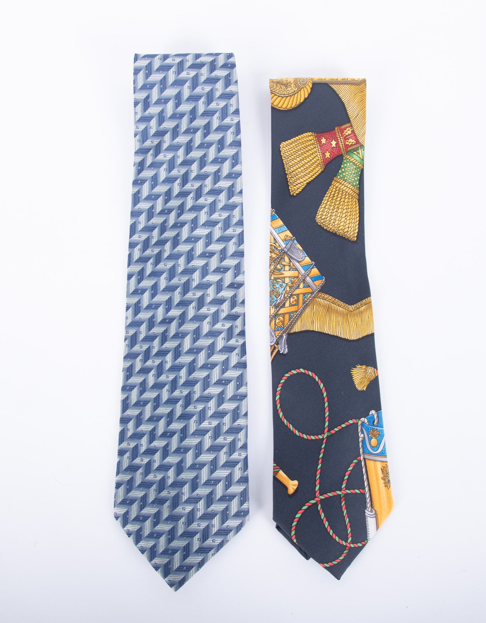 Two Fine Designer Ties by Hermes and Gucci: One Vintage 100% silk Hermes, Made in France with rare gold tone tassels on a black background; together with one Vintage Gucci tie Made in Italy in blue geometric pattern.