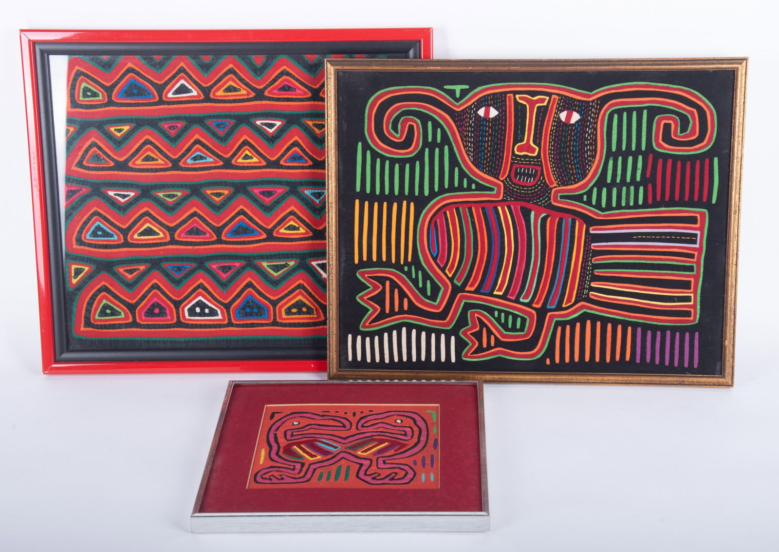 Three Framed Mola Textiles: Brightly colored, depicting various creatures and geometric patterns.