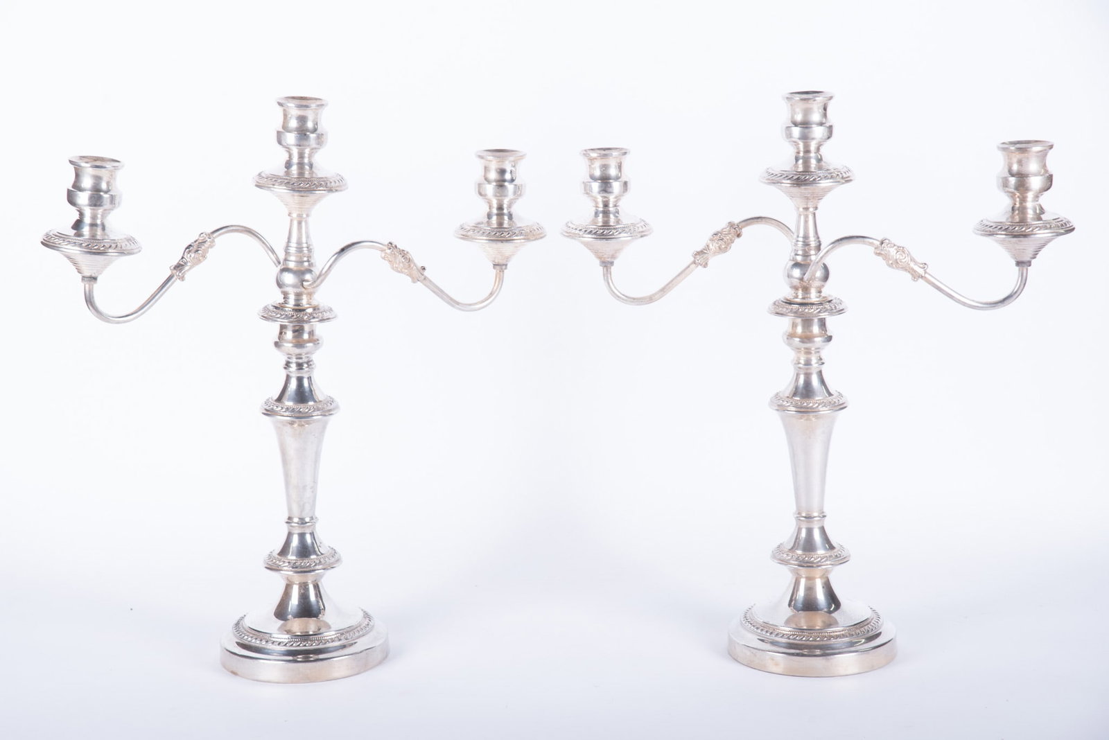 A Pair of English Sheffield 3-Arm Candelabra: England, a pair of Georgian style plated silver candelabra having curved arms and gadrooned edging.