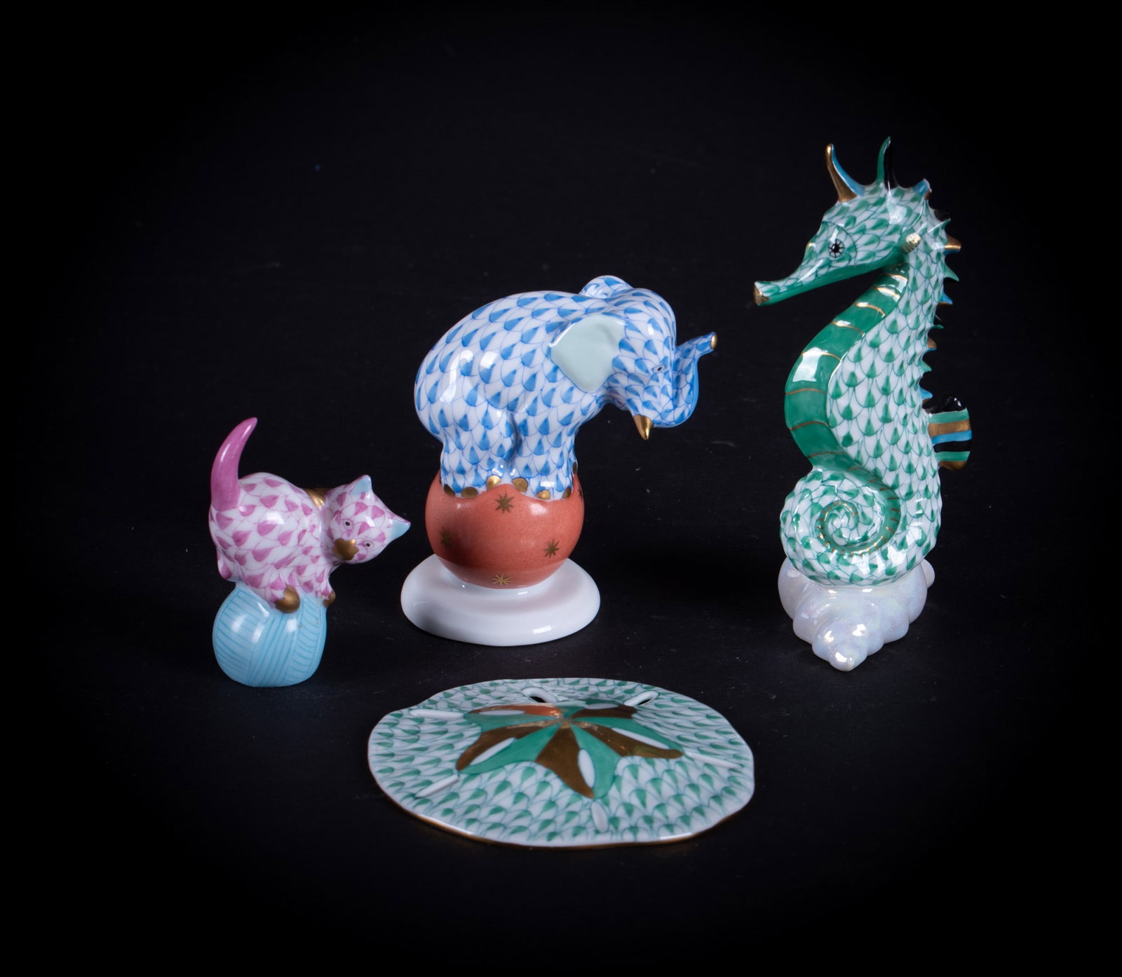 A Collection of Herend Animals and Sea Creatures: Hungary, a 2 3/4 inch circus Elephant atop a ball, a 2 1/4 inch Kitten atop a yarn ball, a 2 3/4 inch diameter Sand Dollar, and a 4 inch tall Seahorse.