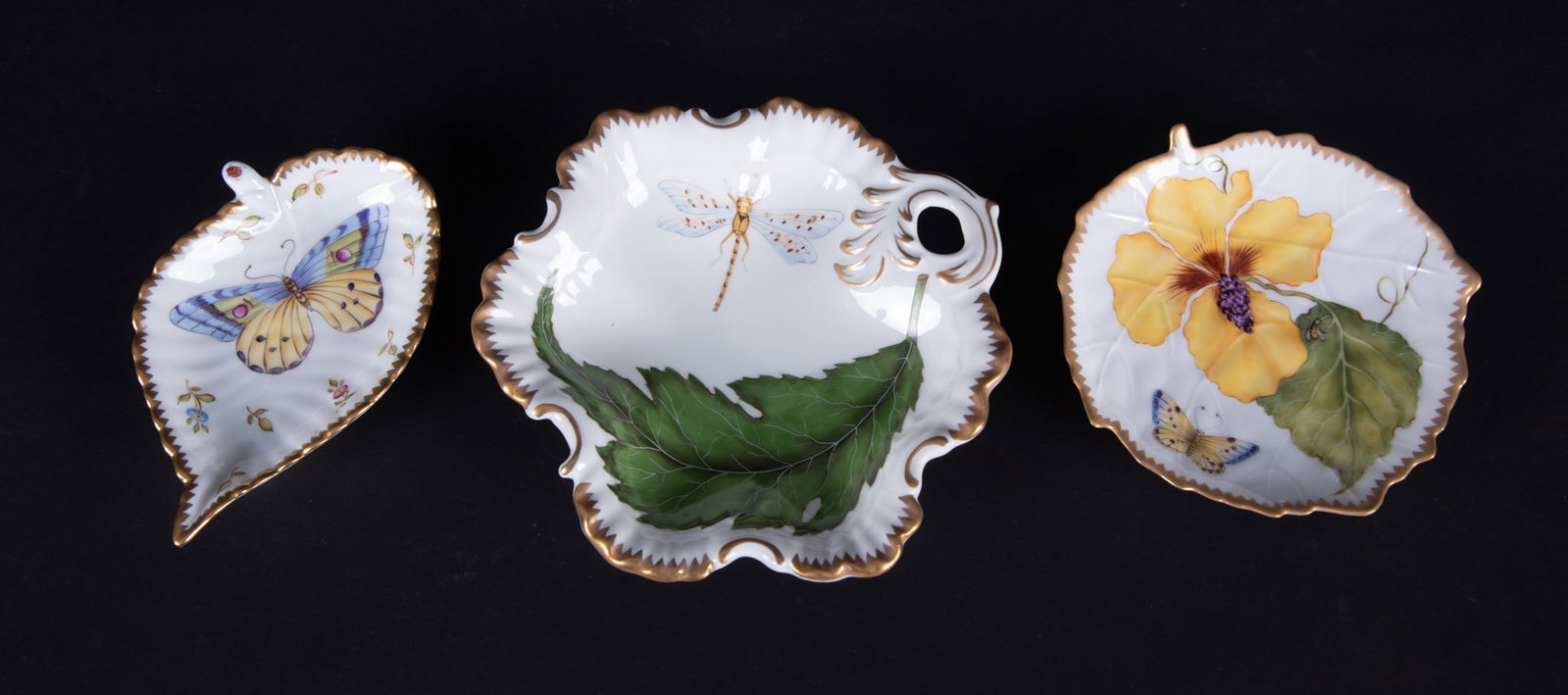 Three Anna Weatherly Hand-Painted Porcelain Table Articles: Hungary, three charming dishes by Anna Weatherley Designs, a leaf-form tray featuring a large butterfly to the central well and ladybug to the stem, a leaf-form tray featuring a large yellow flower an