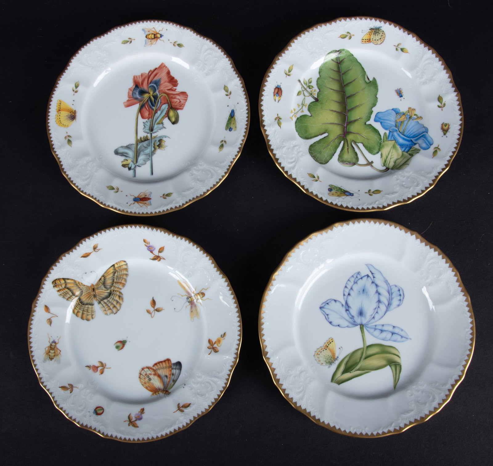 A Collection of Four Anna Weatherley Porcelain Salad Plates: Hungary, of various patterns with the 4 having the same rims and blanks, including a butterfly and insect plate, two tulip plates and a large blooming blue botanica.