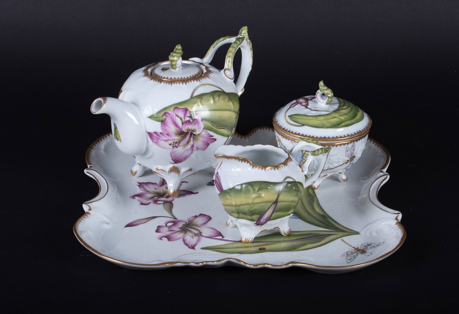 A Fine Anna Weatherley Porcelain Botanical Tea Set: Hungary, all pieces hand signed by Anna Weatherley, the set consists of a 11 3/4 inch Tray with large purple blooms, a butterfly, dragonfly, ladybug and a snail. The lidded Teapot having a floral bloo