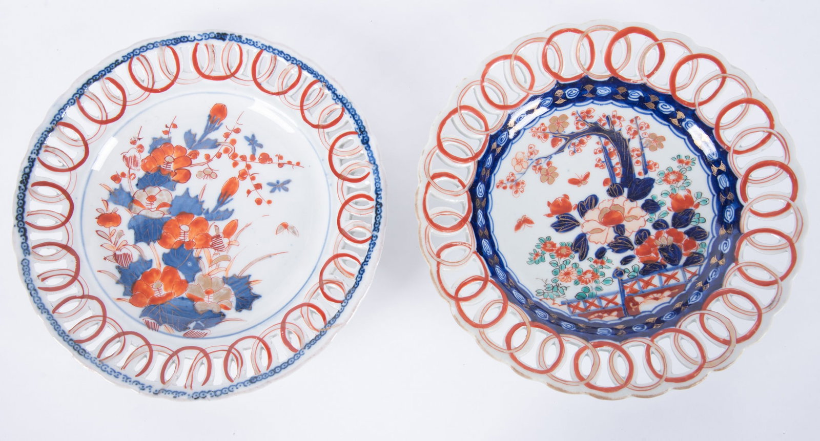 Two 19th Century Imari Scalloped Plates: Meiji period, a fine antique Imari plate with reticulated edge featuring vibrant oranges, blues, greens and gilt highlights, the central well of the plate depicting floral sprays, trees and butterflie