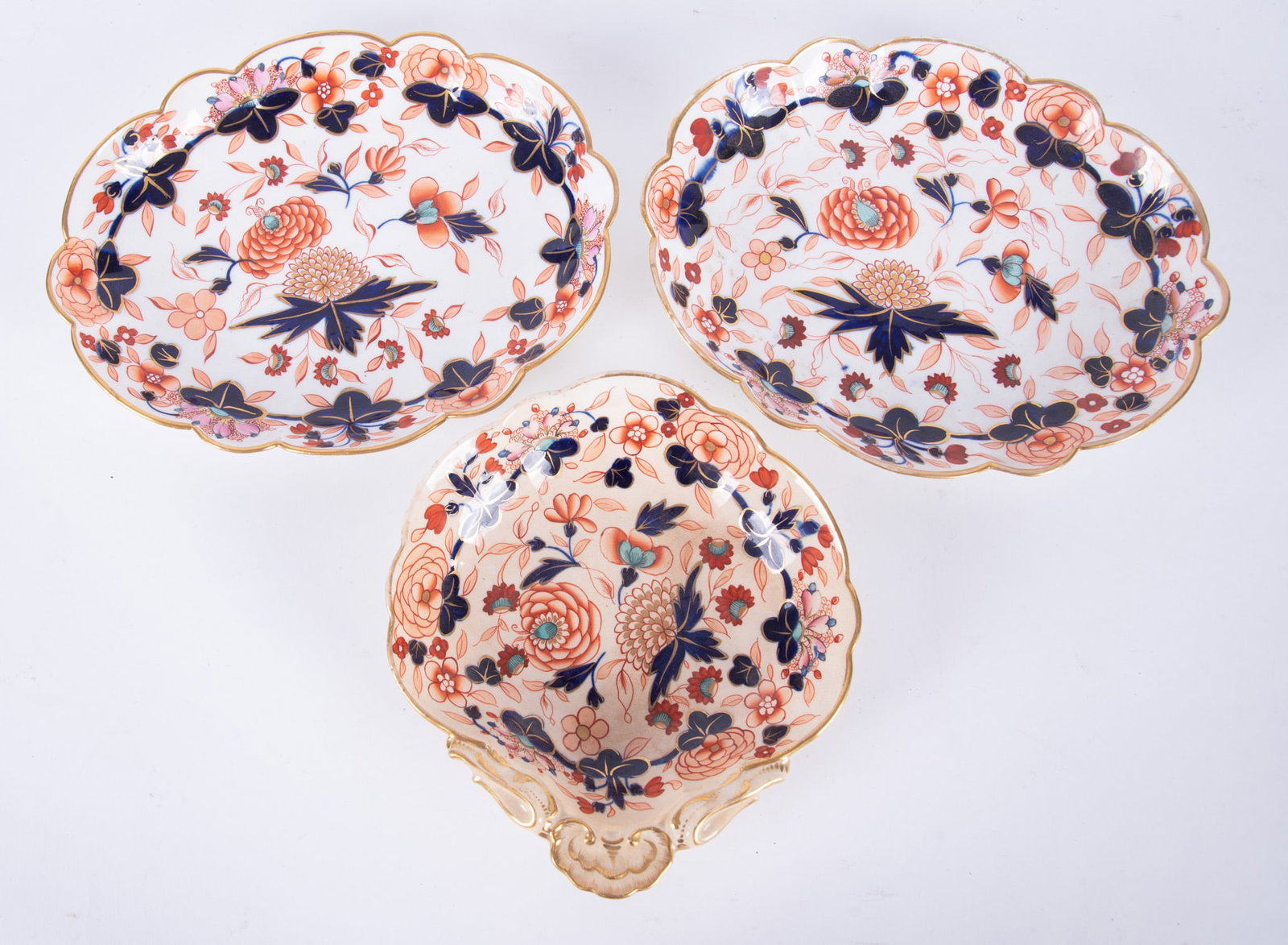Three Antique Staffordshire Imari Style Serving Dishes: England, early 19th century, likely Chamberlain's Worcester, a pair of oval serving dishes having gilt scalloped edges and a handled dish, all in an Asian influenced design.