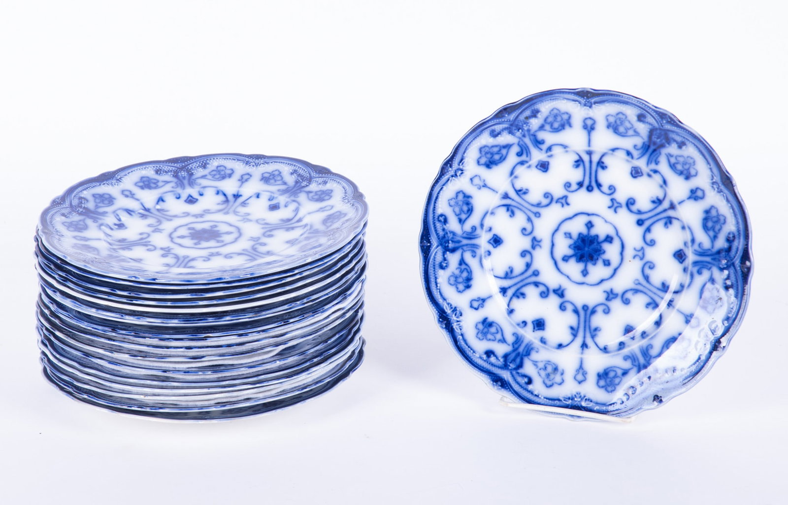A Collection of Twenty-Six Flow Blue Staffordshire Luncheon Plates, Conway by New Warf Pottery: Burslem, England, circa 1890, a rarely found set of 26 luncheon size plates (9 inch) in the Conway pattern. Produced roughly from 1878-1894, the pattern features a stylized floral and geometric design