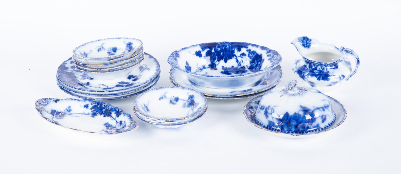 A Collection of Rare Staffordshire Flow Blue Serving Pieces, Virginia by John Maddock and Sons: England, circa 1890, by John Maddock and Sons in the desirable Virginia pattern, a difficult to find round lidded butter dish with drain piece having gilt highlights, a 9 inch oval vegetable bowl