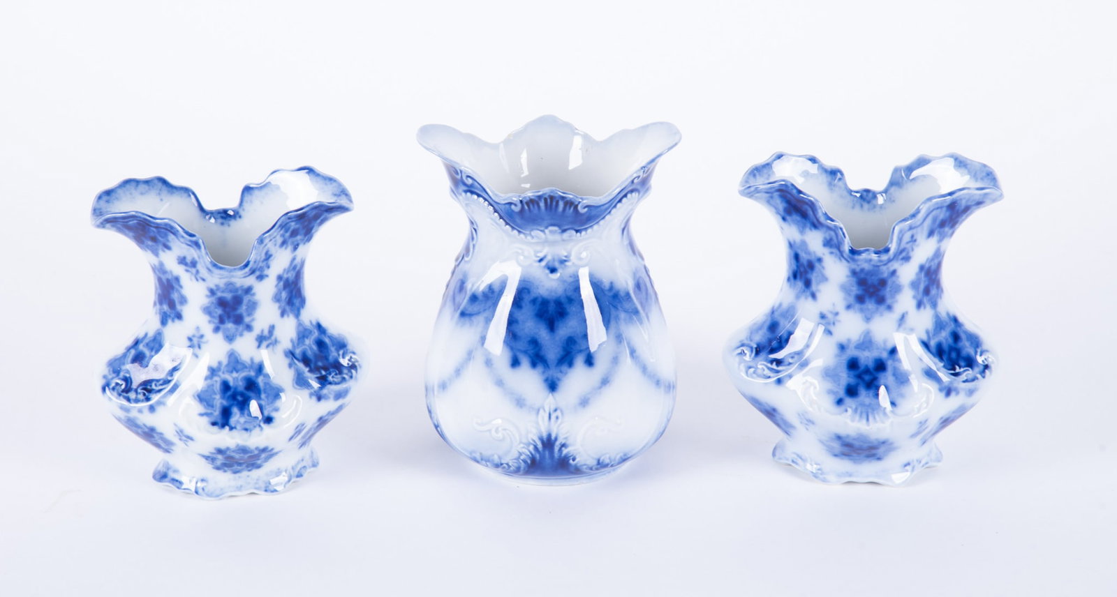 Three Antique Staffordshire Flow Blue Spill Vases: England, late 19th century, a pair of floral decorated vases by W.H. Grindley and a Art Nouveau stylized flow blue vase with raised decoration.