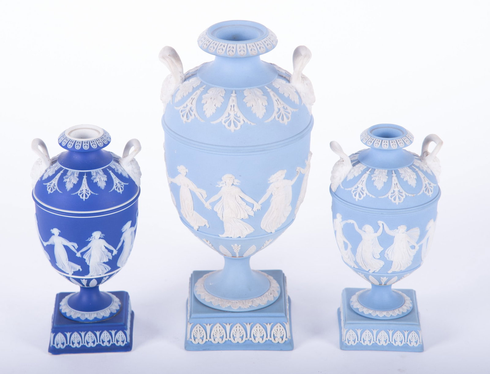 Three Antique Wedgwood Jasperware Dancing Hours Urns: England, 19th century, a grouping of three bolted urns in the dancing hours jasperware pattern featuring maidens around the central core panel, with bacchanalian handles, all marked Wedgwood (only).
