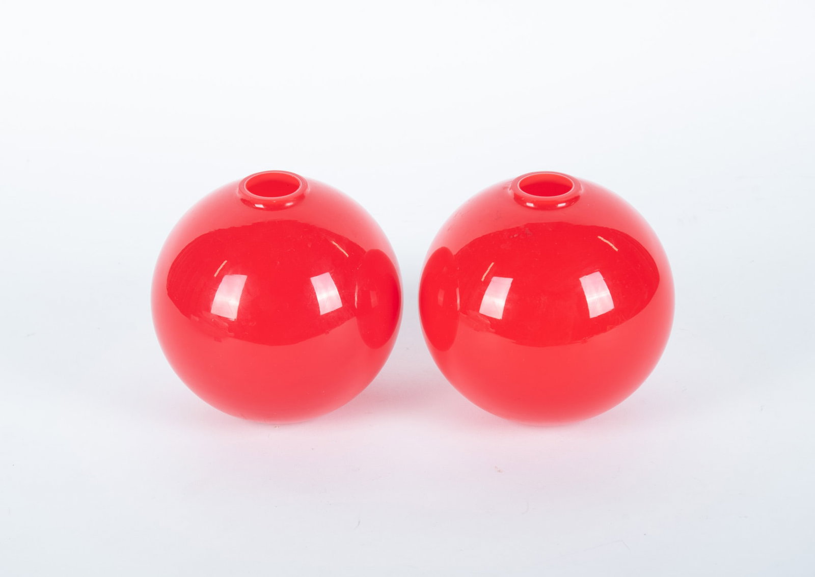 A Pair of Modern Red Glass Vases, Larry Laslo for Mikasa: Circa 1980s, a pair of cased deep red globe-form vases, designed by Laslo and produced in Japan for Mikasa.