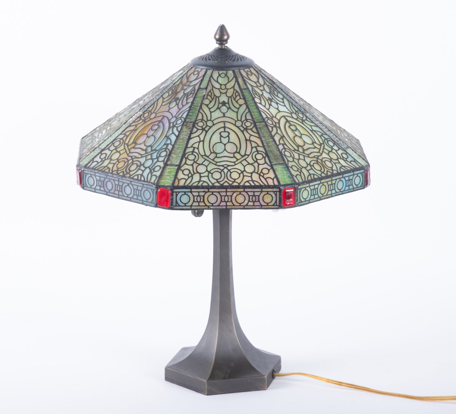 A Dale Tiffany Slag Glass Table Lamp with Red Jewel Accents: A Dale Tiffany Slag Glass Table Lamp with Red Jewel Accents Having a faceted octagonal form, the shade composed of segmented panels featuring an art nouveau inspired geometric pattern and shades of gr