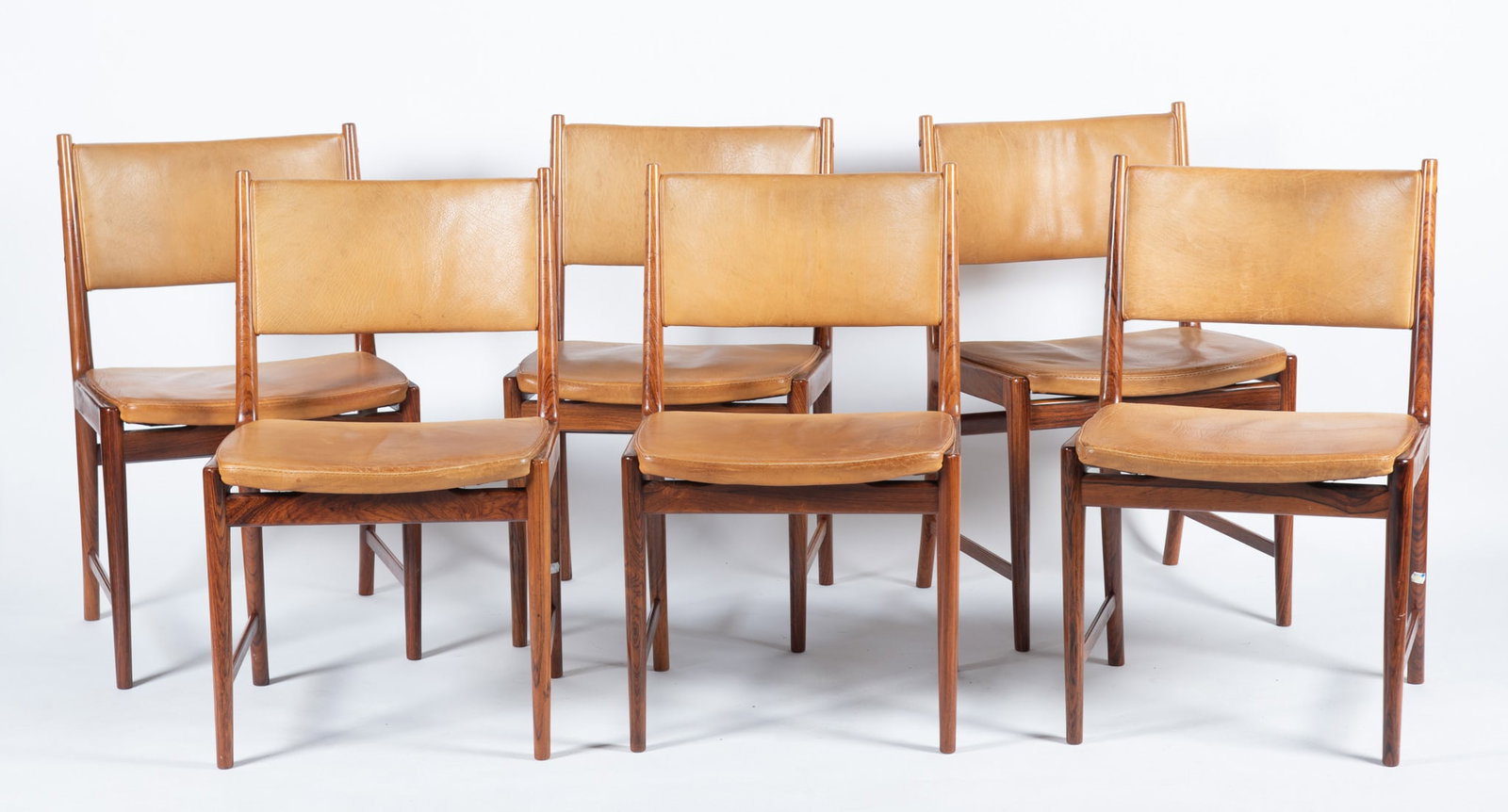 Set of Six Kai Lyngfeldt Larsen Mid Century Dining Chairs: Set of Six Kai Lyngfeldt Larsen Mid Century Dining Chairs Danish, mid-20th century, rosewood. Six (6) side chairs, each back and seat upholstered in tan leather, the straight, tapering legs joined by 
