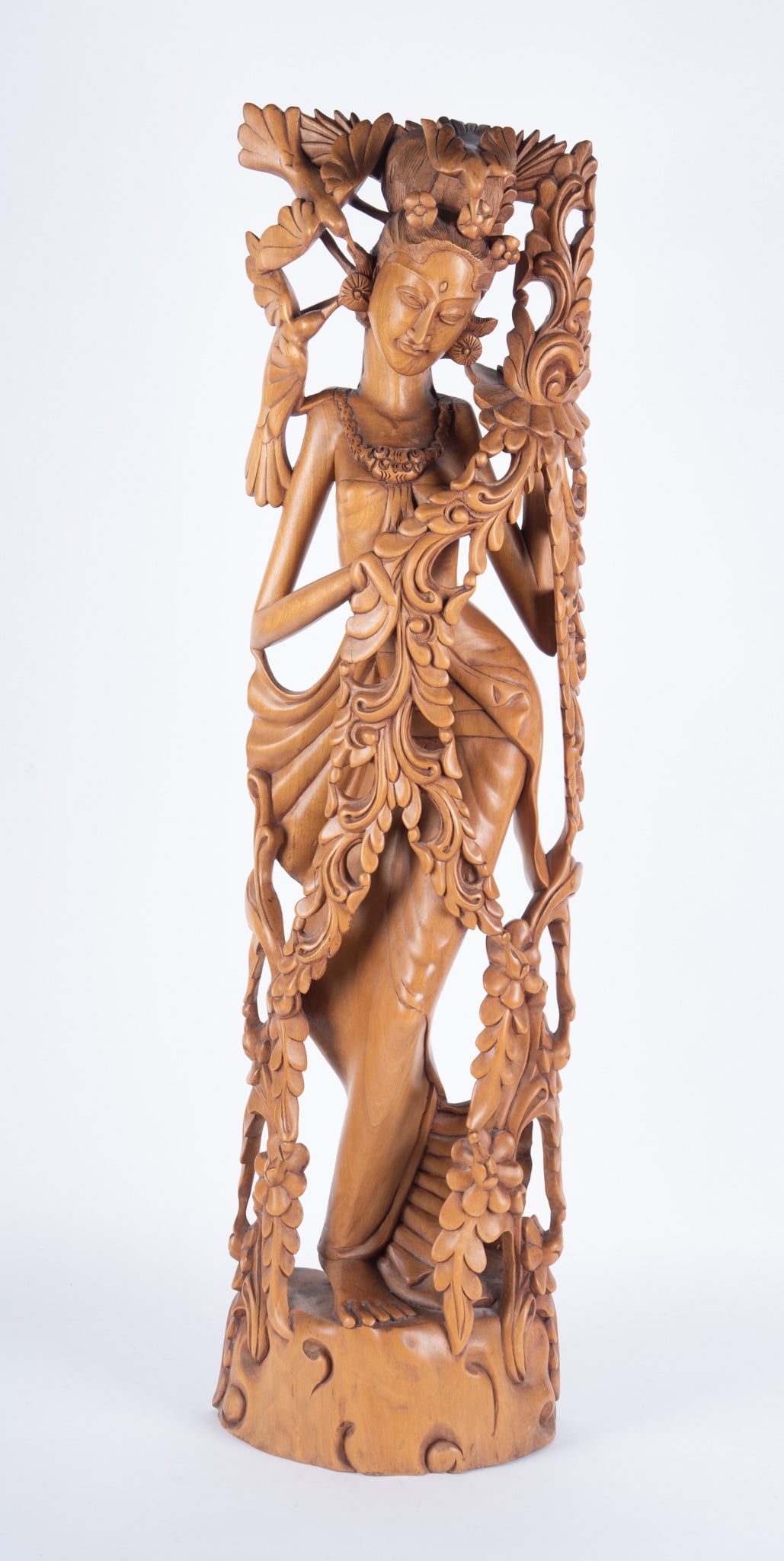 A Carved Indonesian Sculpture of a Maiden: A Carved Indonesian Sculpture of a Maiden Indonesia, a large carved wood figure of a dancing woman. 10 1/2 x 39 inches
