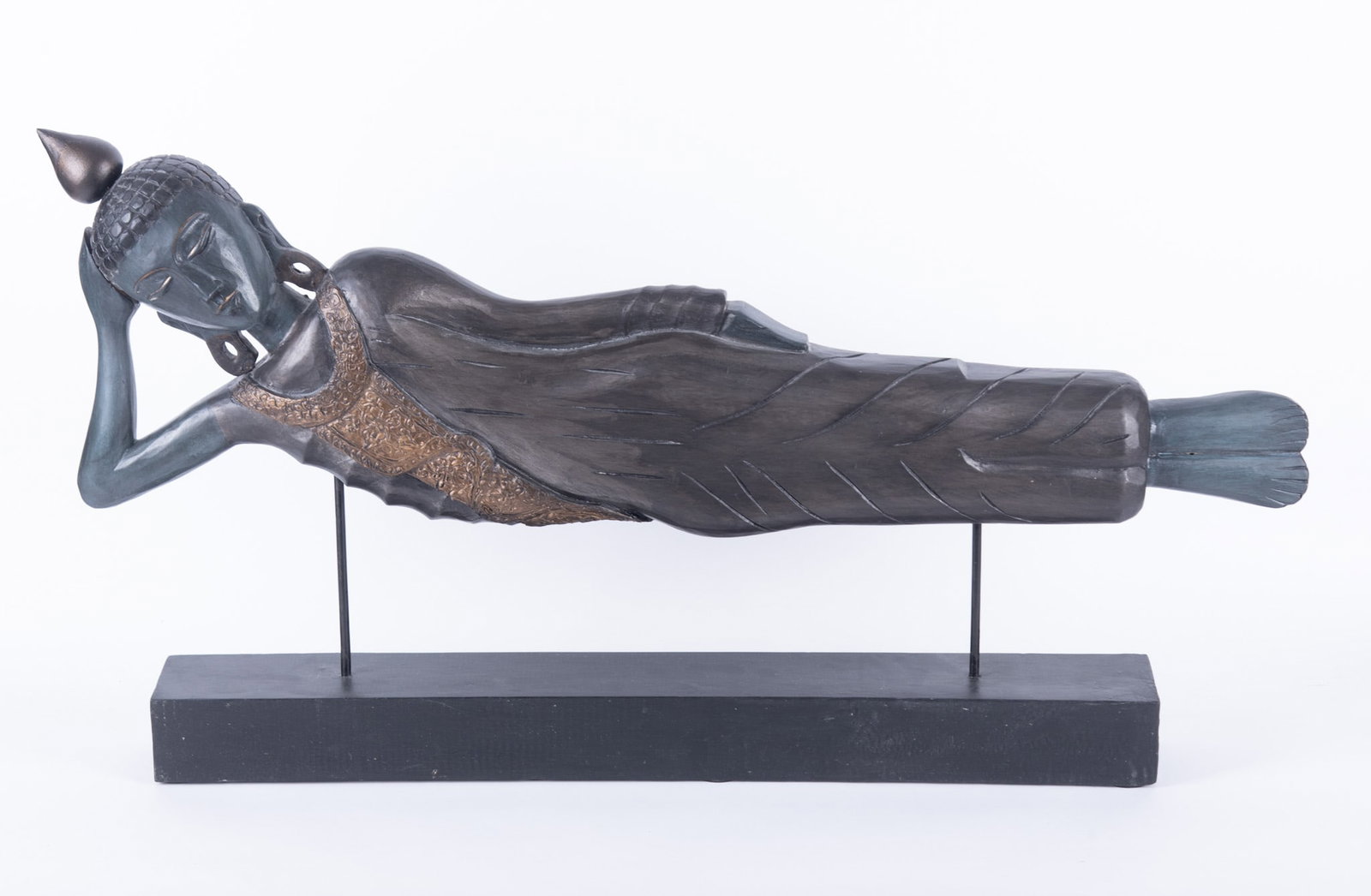 A Large Carved Wood Sculpture of a Reclining Buddha: A Large Carved Wood Sculpture of a Reclining Buddha The sculpture of the Buddha held up on a wood and metal stand. 20 1/2 x 37 inches