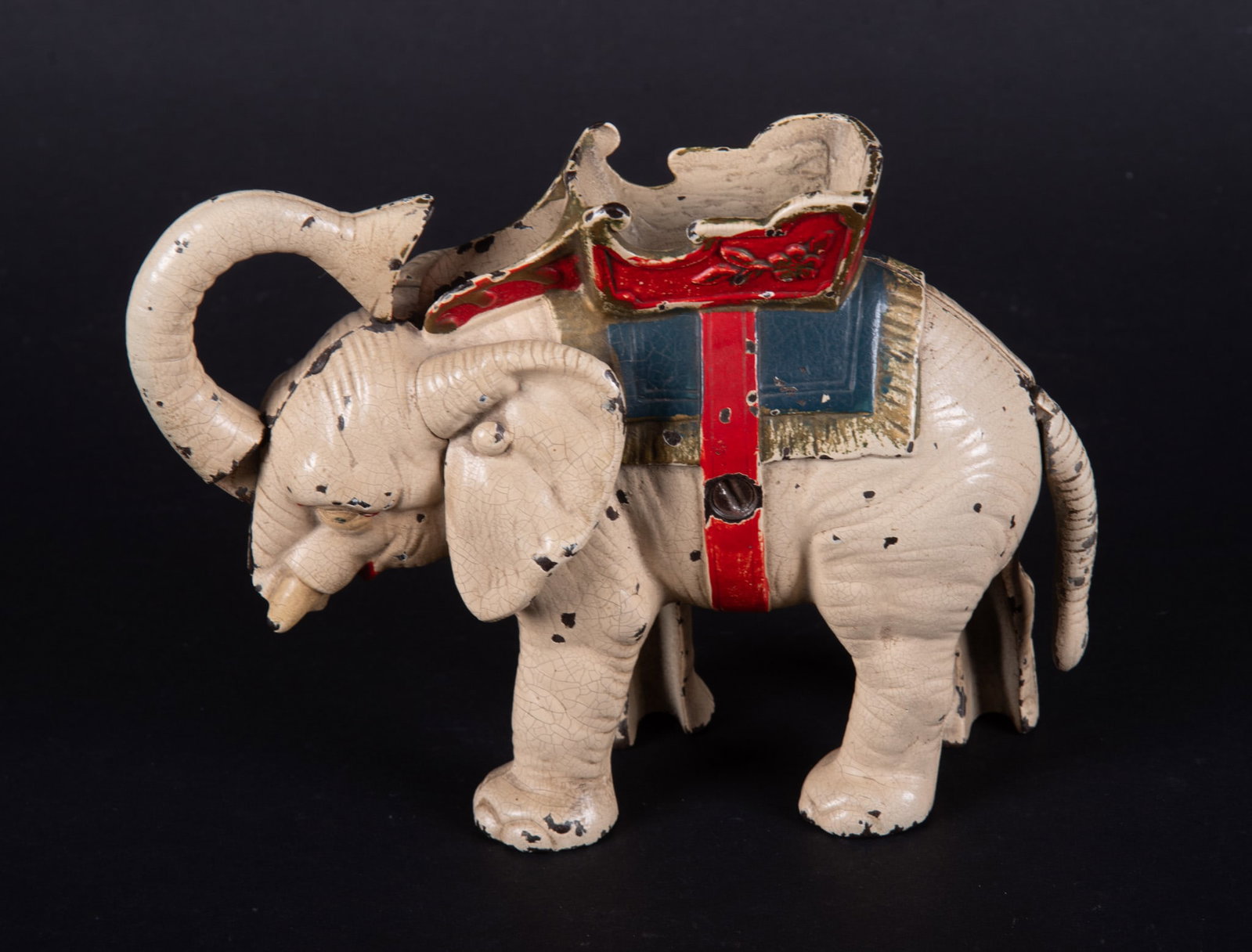 Hubley White Elephant Cast Iron Mechanical Bank: Hubley White Elephant Cast Iron Mechanical Bank Circa 1930, Hubley Manufacturing Company, a working mechanical bank of an elephant wearing a howdah. 5 1/2 x 7 1/2 inches