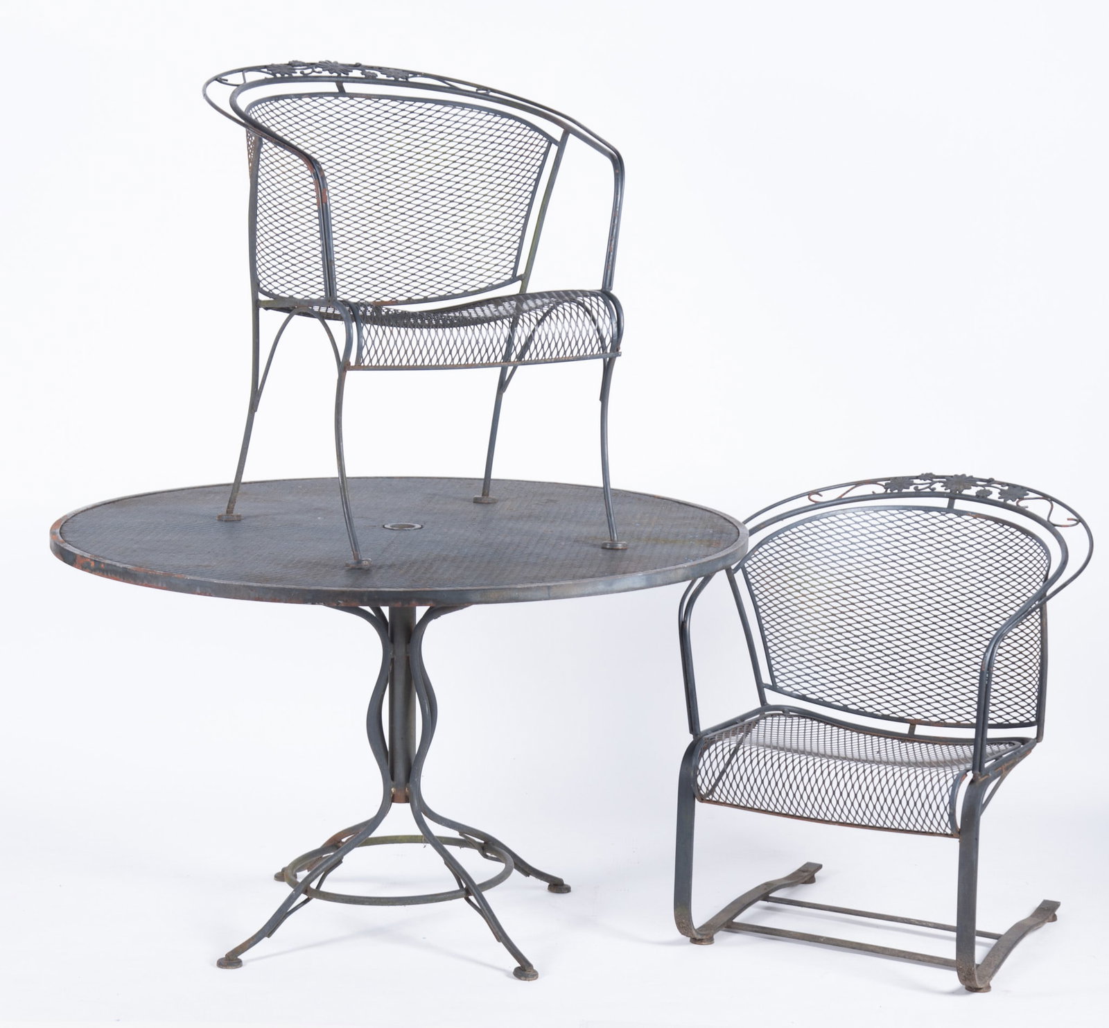 Black Wrought Iron Patio Set: Black Wrought Iron Patio Set (6 pieces) Circular table and four barrel back chairs along with a matching spring rocker. Woodard Briarwood design. 28 1/2 x 47 1/2 inches (table)