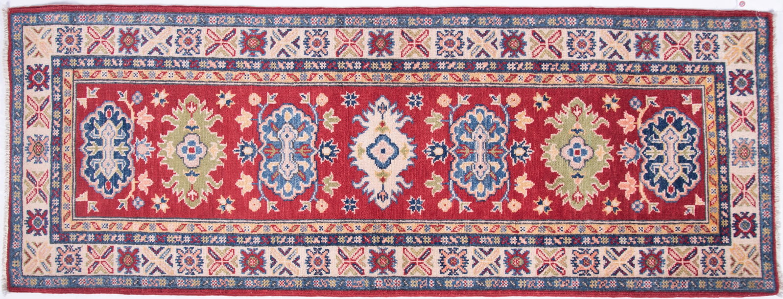 Handwoven Kazak Runner: Handwoven Kazak Runner Red field having seven shaped motifs in shades of blue, ivory, olive and red all centering a primary border and three guard borders. 2' 3" x 6'