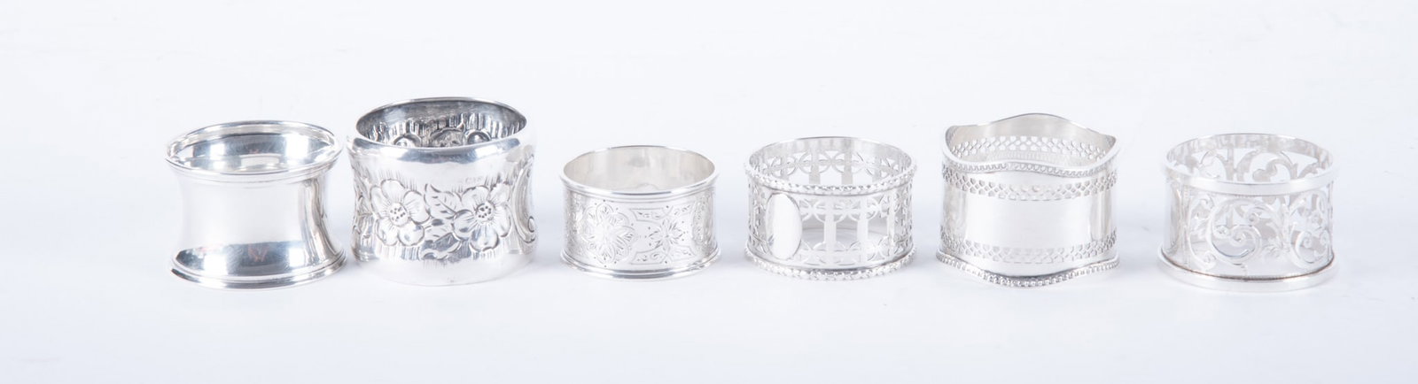 Six English Sterling Silver Napkin Rings: Six English Sterling Silver Napkin Rings England, an assortment of 6 vintage and antique sterling silver napkin rings, some with reticulated openings. 4.15 total troy ounces Widest: 1 1/2 inches