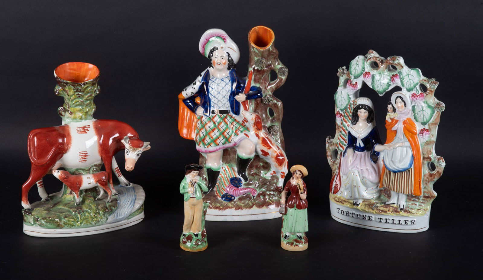 Five Antique English Staffordshire Pottery Figures: Five Antique English Staffordshire Pottery Figures England, late19th/early 20th century, a 13 1/2 inch tall Scottish Highlander with Spaniel spill vase (minor paint loss, nicks), a 11 1/2 inch red/whi