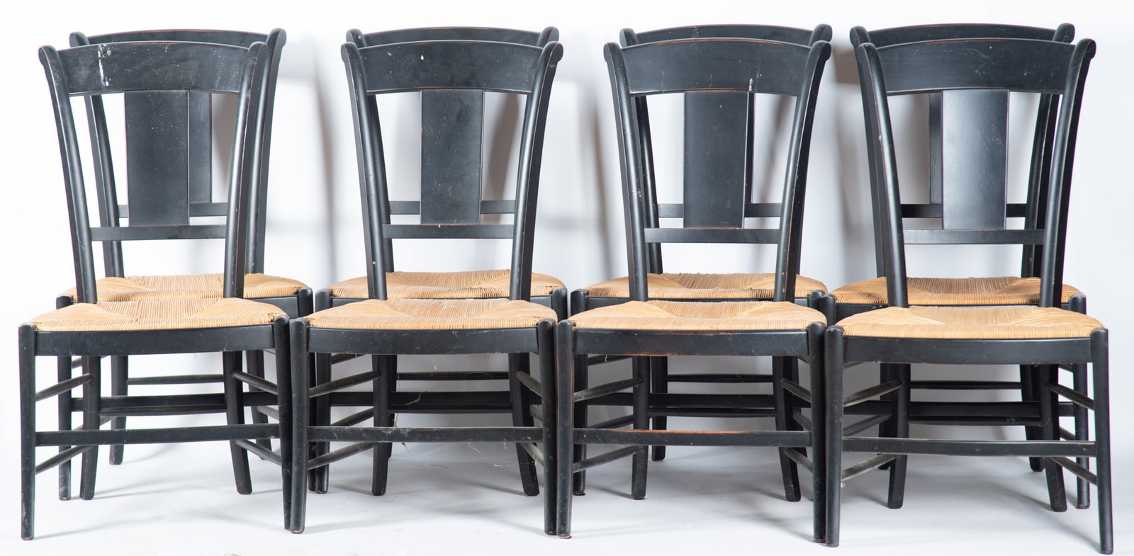 Set of Eight Italian Side Chairs: Set of Eight Italian Side Chairs Black painted with slightly arched head rails above single splats and rush seats resting on sabre legs and support stretchers 39 x 22 x 18 inches