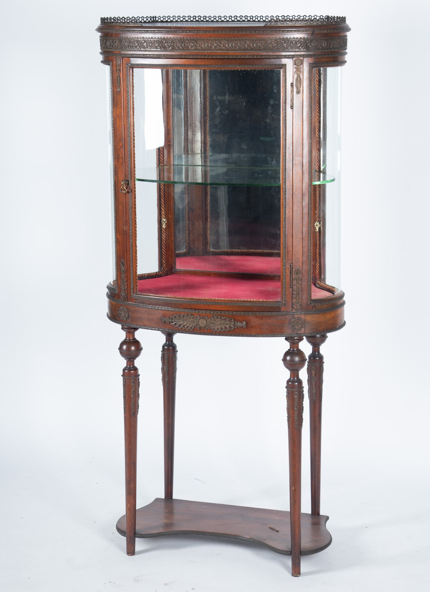 Antique Louis XVI Vitrine Cabinet: Antique Louis XVI Vitrine Cabinet Mahogany. Brass gallery top over the mirror-backed display interior with three convex glass panels to the sides and door, and brass mounts to the frieze and apron rai
