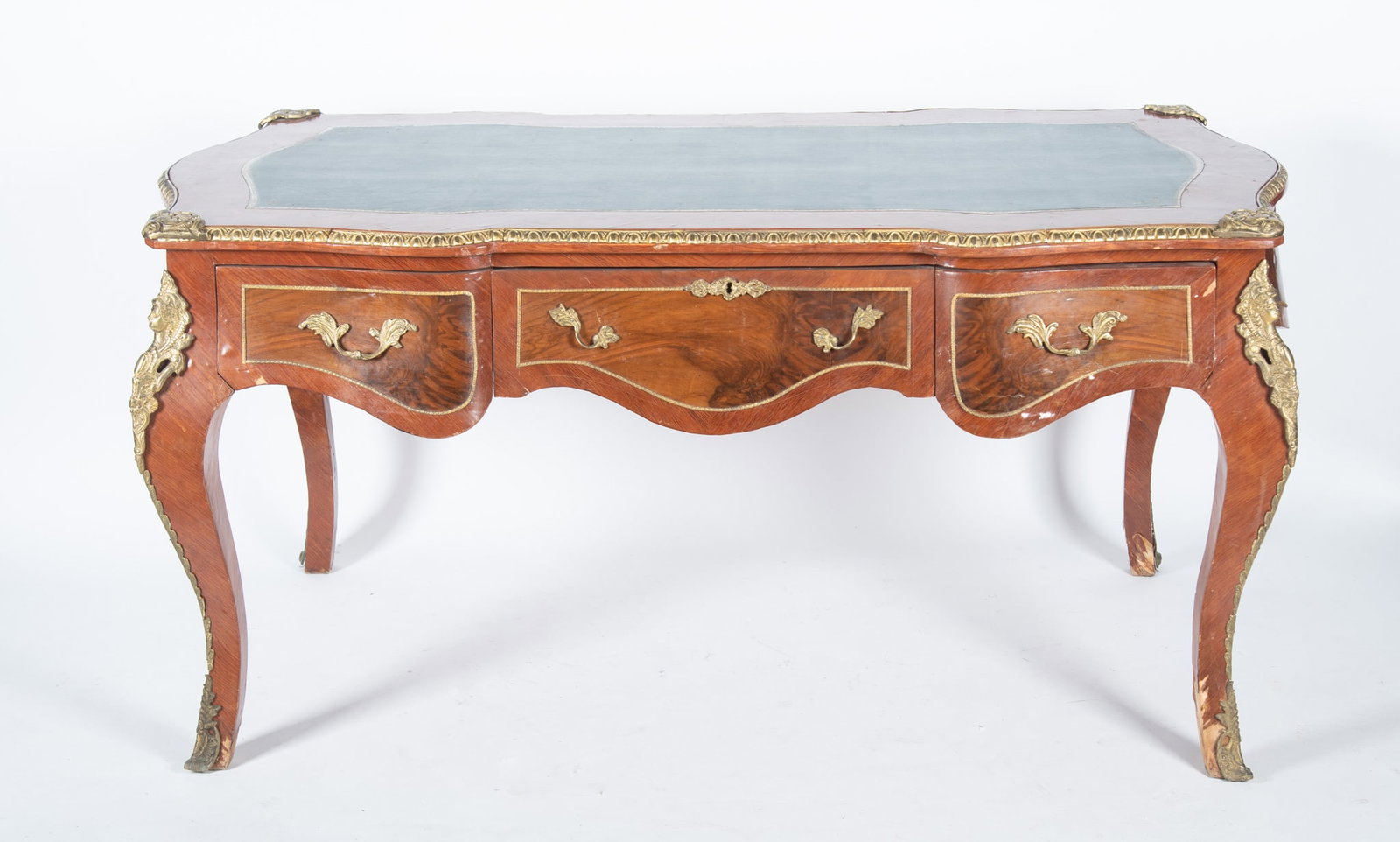 A French Louis XV Bureau Plat: A French Louis XV Bureau Plat Inset green leather top of serpentine form, having gilt ormolu figural mounts with a long drawer centering two short drawers ending on ormolu-mounted legs. 32 3/4 x 67 x