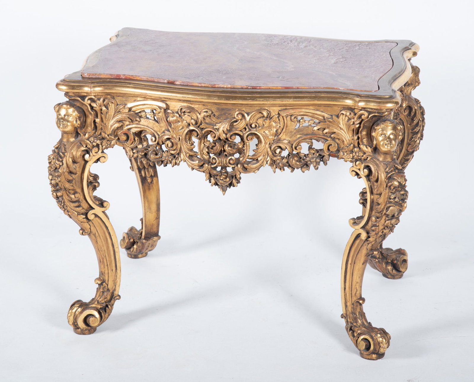 Louis XV Design Center Table: Louis XV Design Center Table The red inset veined marble top with all around serpentine sides above a heavily carved gilt wood frieze with reticulated decoration and carved figures to the corners