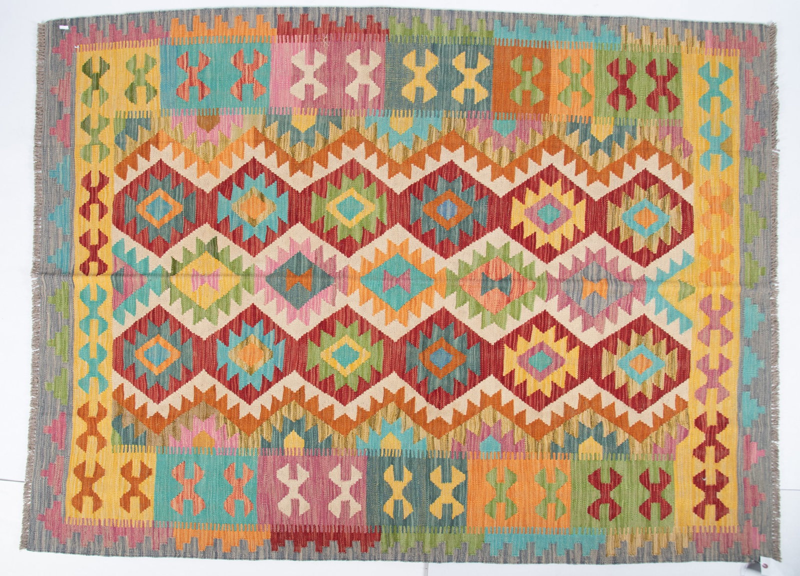 Hand Knotted Kilim Area Rug: Hand Knotted Kilim Area Rug A field with repetitive diamonds in alternating shades of green, red, gold and blue. 5' 1" x 6' 7"