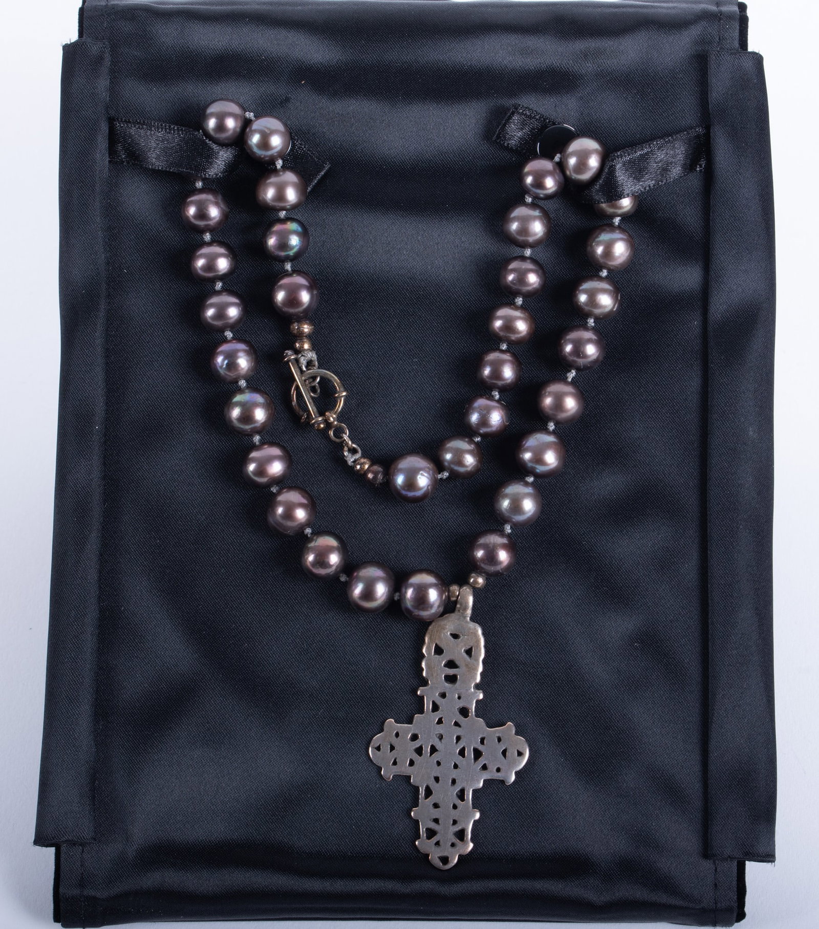 Peacock Fresh Water Pearl Necklace with Cross: Peacock Fresh Water Pearl Necklace with Cross An unusual openwork cross that strongly represents an Ethiopian Coptic Cross. Sand cast in a silver-tone metal and beautifully crafted with artistic