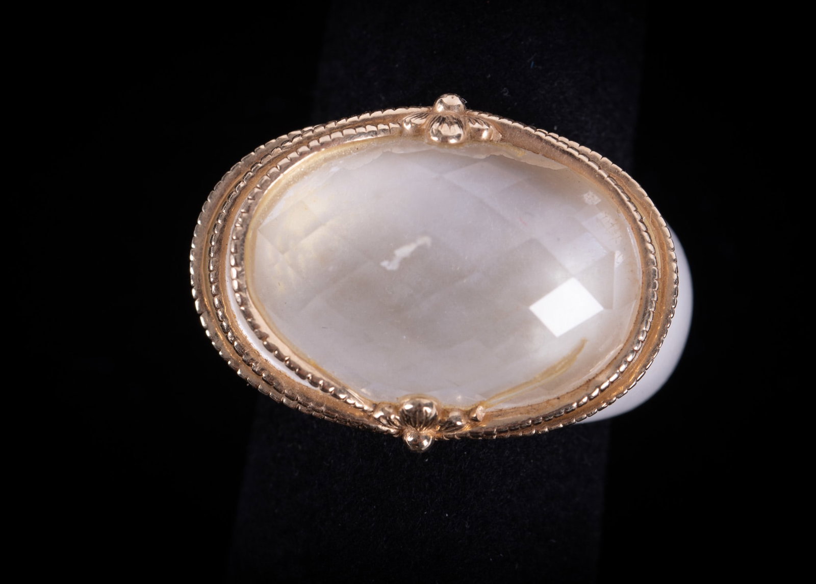 Elizabeth Adams White Ceramic-Faceted Quartz Ring: Elizabeth Adams White Ceramic-Faceted Quartz Ring The clear quartz in this ring is surrounded by delicately twisted cordwork in 14K yellow gold. One of the cords is missing. Ring size is 7.