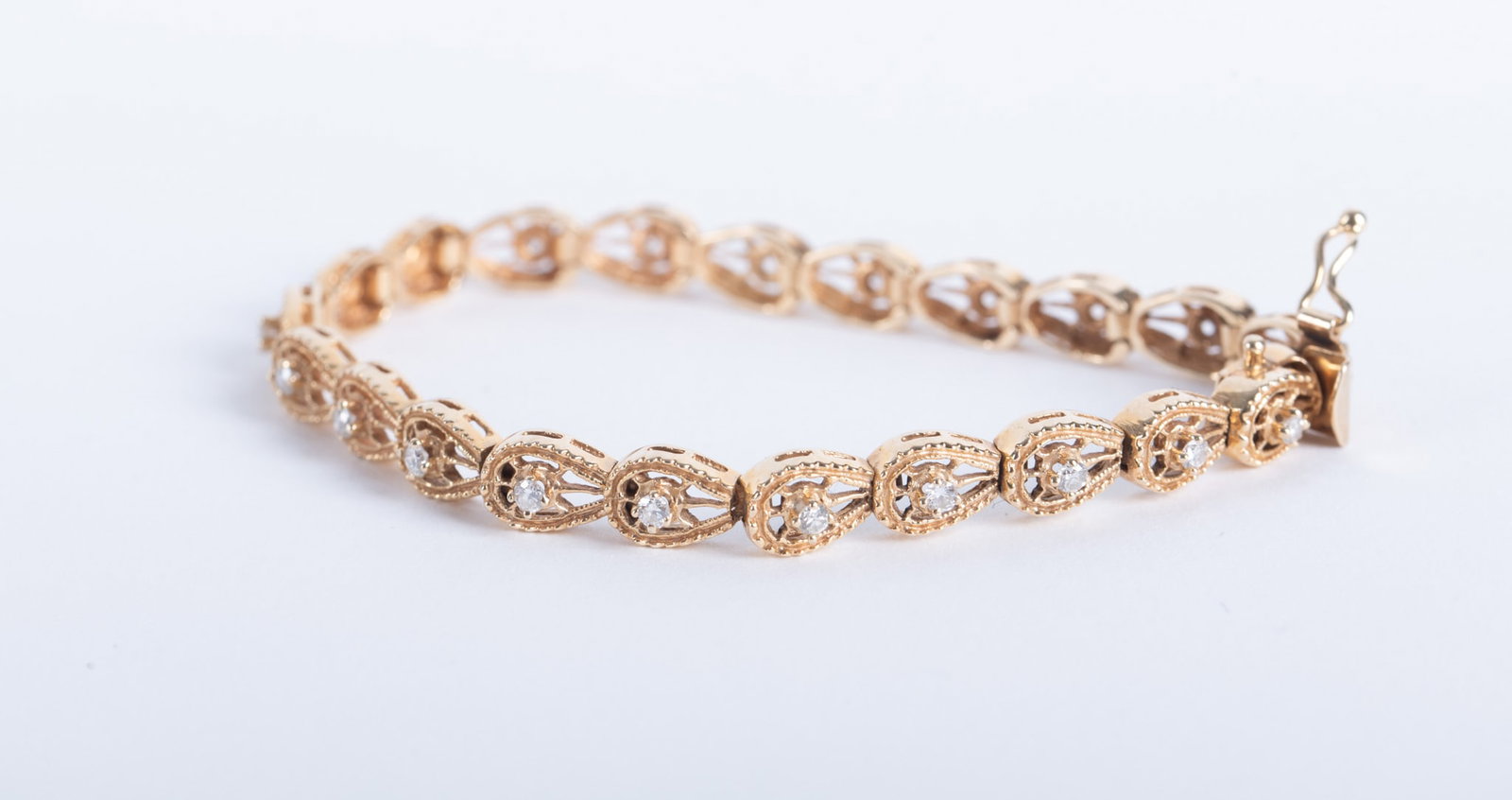 Vintage 14K Yellow Gold Diamond Bracelet: Vintage 14K Yellow Gold Diamond Bracelet This bracelet has repeating pear shaped links, each set with a .04 carat round prong set diamond. The design is reminiscent of Art Deco revival. The length is