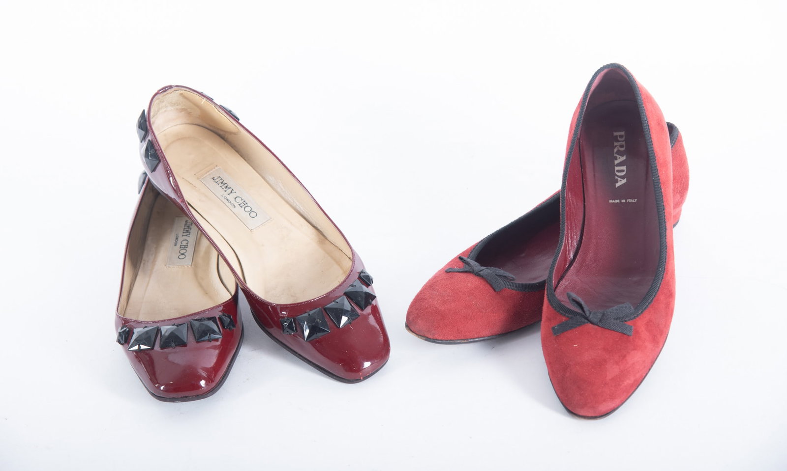 Two Pairs Ladies Designer Flat Shoes by Jimmie Choo and Prada: Two Pairs Ladies Designer Flat Shoes by Jimmie Choo and Prada Jimmie Choo, London, burgundy patent leather flat with black buttons near toe, Made In Italy, size 37; together with Prada flat in red sue