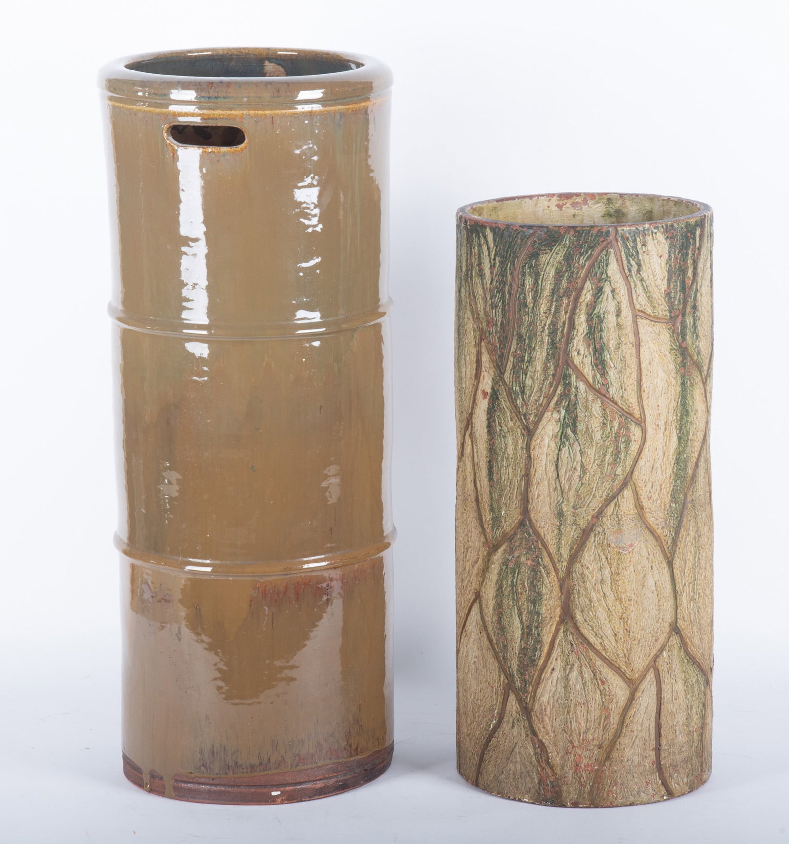 Two Glazed Earthenware Umbrella or Cane Holders: Two Glazed Earthenware Umbrella or Cane Holders A high green glaze umbrella stand mimicking bamboo, paired with a painted pottery stand in the shape of a trunk. 20 1/2 and 28 inches tall