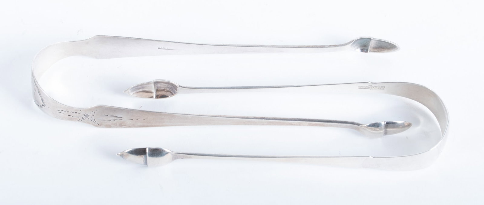 Two American Antique Silver Tongs: Two American Antique Silver Tongs A late 18th/early 19th century pair of tongs by Joel Sayre (1778-1818) with acorn ends and monogrammed; paired with a bright-cut tong by WB&T. 2.21 total troy ounces 