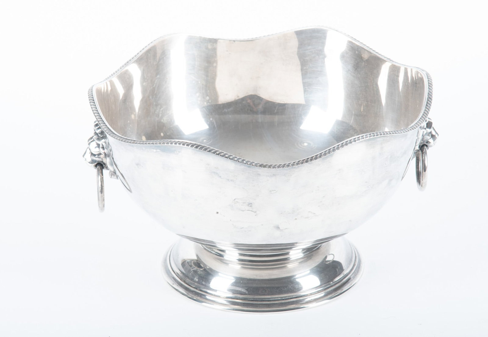 An English Plated Silver Ice or Fruit Bowl: An English Plated Silver Ice or Fruit Bowl England, 20th century, a good Sheffield style center bowl having lion mask handles and shaped gadroon edged lip. 6 1/2 x 11 1/2 inches