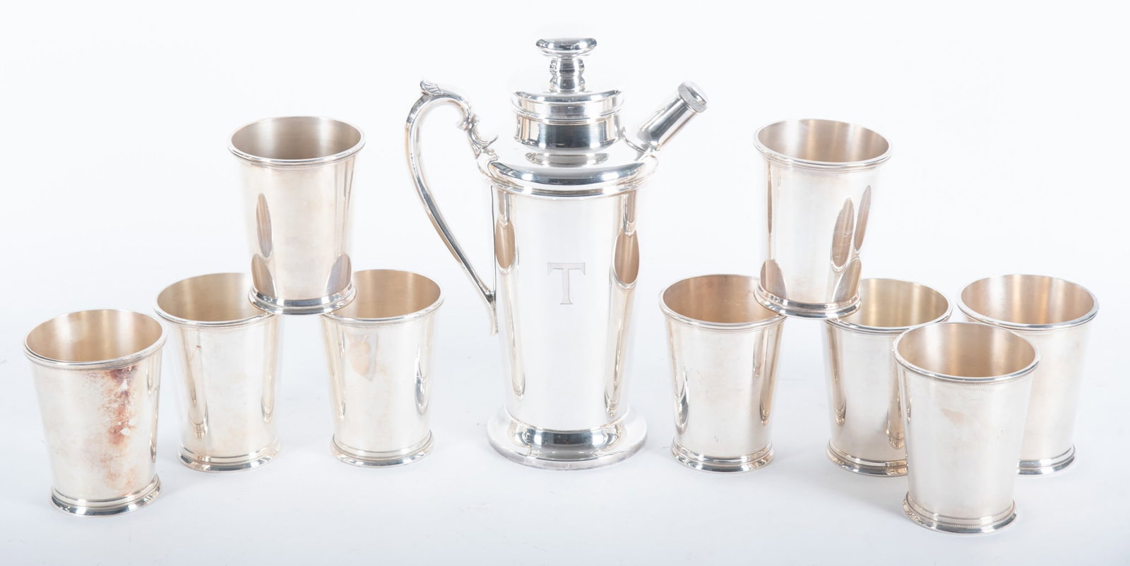 Nine International Silver Co. Plated Silver Mint Julep Cups, together with a Plated Silver Cocktail: Nine International Silver Co. Plated Silver Mint Julep Cups, together with a Plated Silver Cocktail Shaker The cocktail shaker and three juleps are monogrammed "T"; one cup has a small dent. Height of