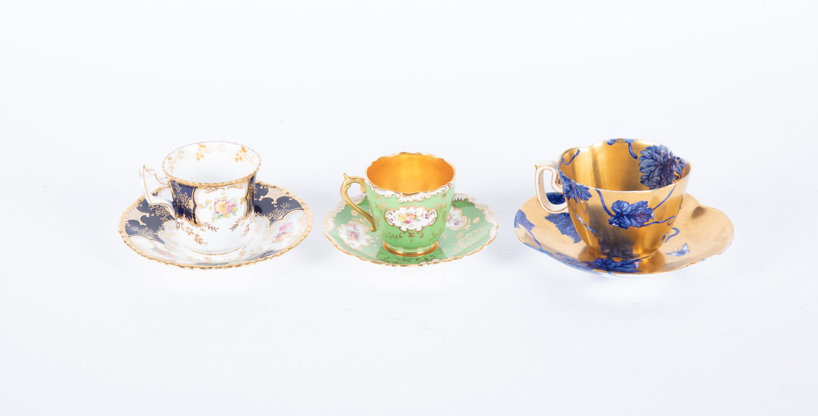 Three Antique Coalport Porcelain Cups and Saucers: Three Antique Coalport Porcelain Cups and Saucers England, late 19th/early 20th century, the lot includes an unusual Aesthetic movement botanical cup and saucer, the gold gilt ground highlighted with 