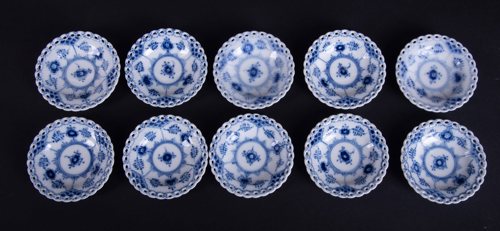 Twelve Royal Copenhagen Blue Fluted Full Lace Butter Pats: Twelve Royal Copenhagen Blue Fluted Full Lace Butter Pats Denmark, pattern 1004, 12 butter pats by Royal Copenhagen, each having white ground with delicate blue botanical floral designs. 3 inch diamet