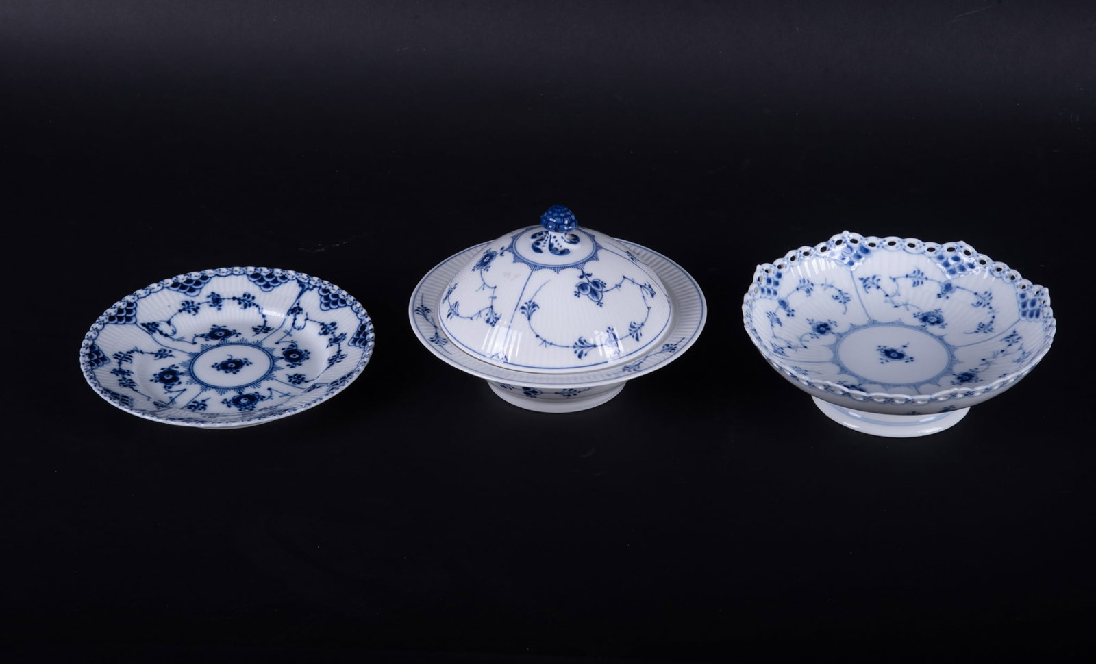 Three Royal Copenhagen Blue Fluted and Full Lace Porcelain Table Articles: Three Royal Copenhagen Blue Fluted and Full Lace Porcelain Table Articles Denmark, a circa 1968 Blue Fluted Full Lace cake disk, a Blue Fluted Full Lace 7 inch plate, and a Blue Fluted covered dish. C