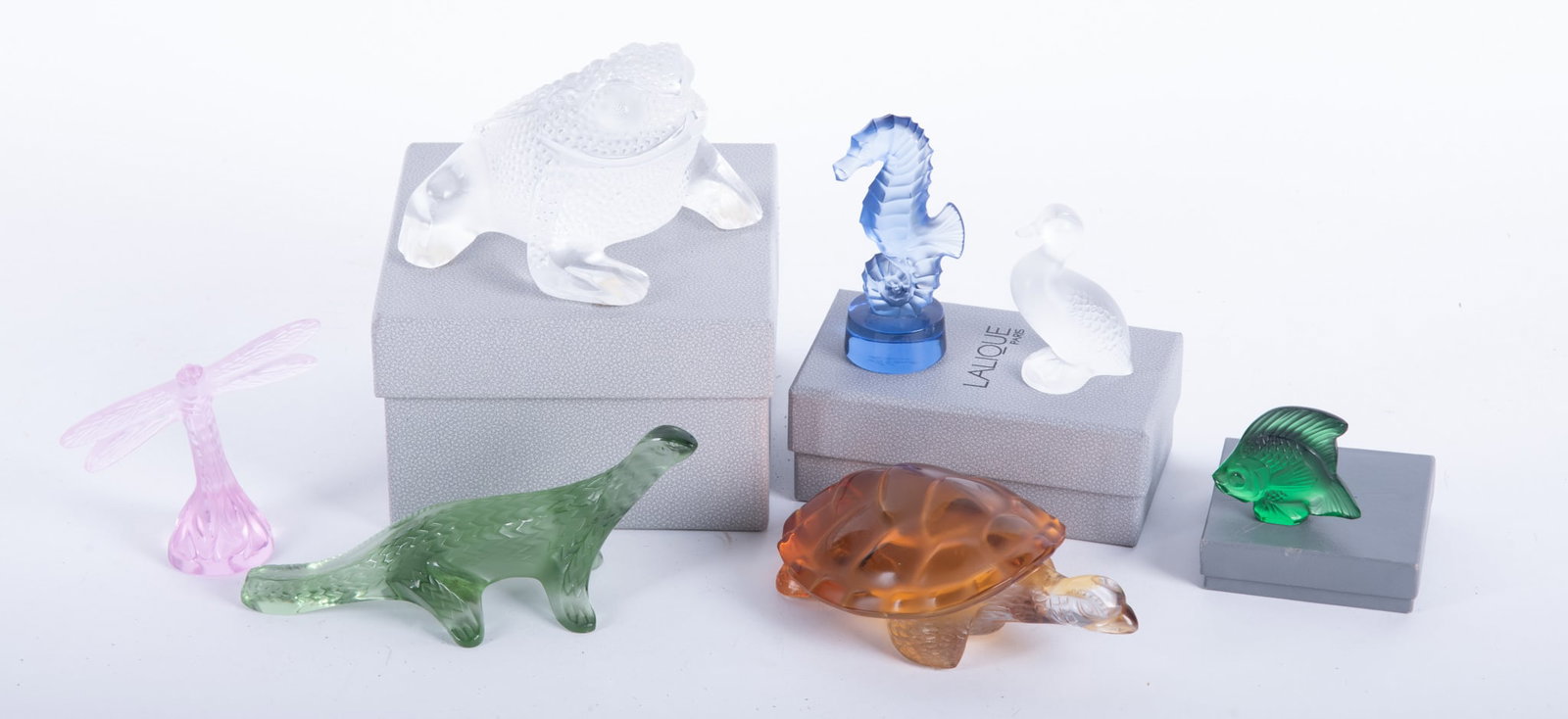 Seven Lalique Crystal Figures: Seven Lalique Crystal Figures (7) Seven figures include; Gregorie Toad, Amber Turtle, Bamako Lizard, Seahorse, Dragonfly, Frosted Duck, and Green Meadow Fish. 3 1/4 x 4 1/4 x 4 3/4 inches (toad)