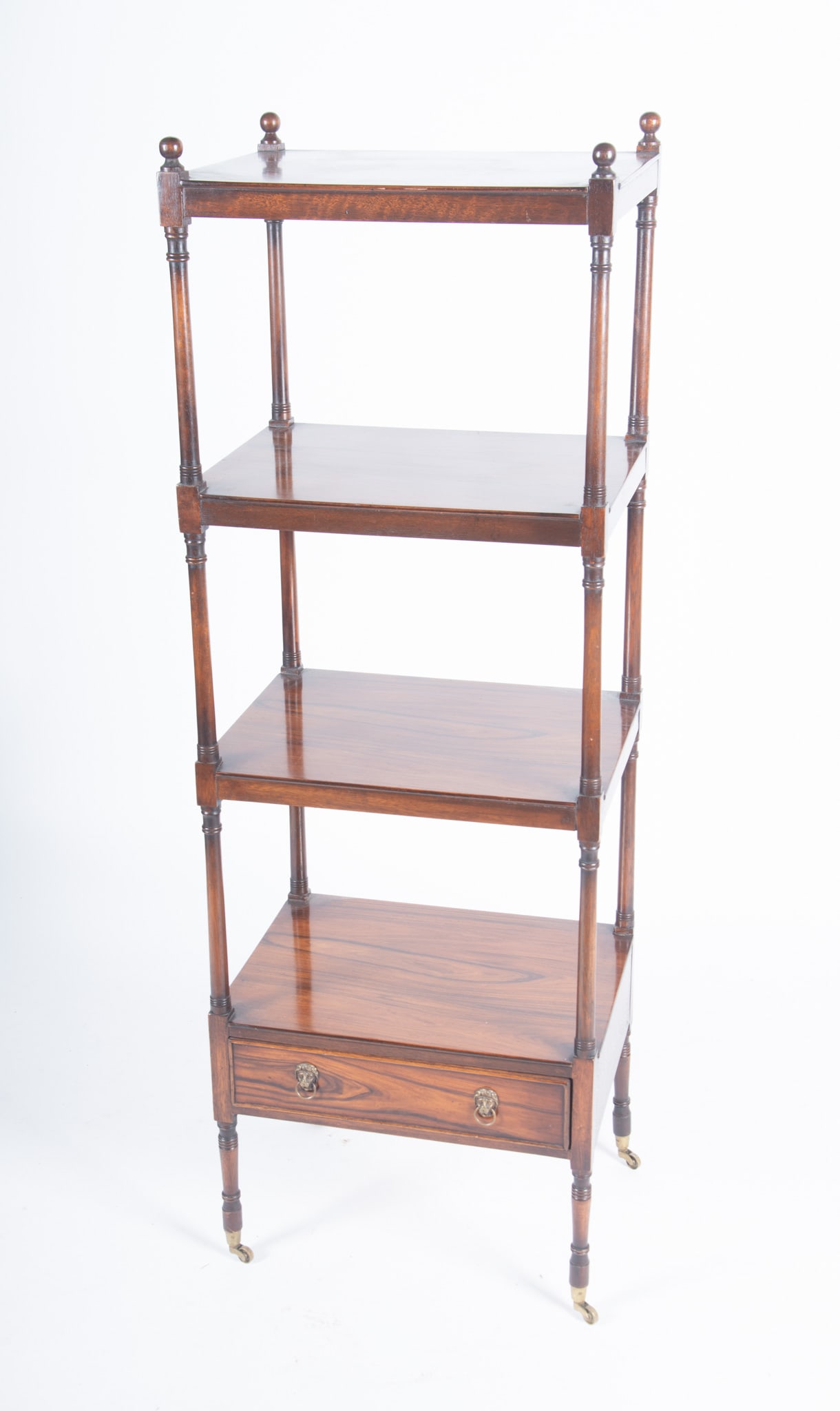 Regency Style Whatnot Shelf: Regency Style Whatnot Shelf Four orb form finials with four open shelves above a single drawer with ringed lion mask pulls ending on casters. 55 1/2 x 19 x 14 inches