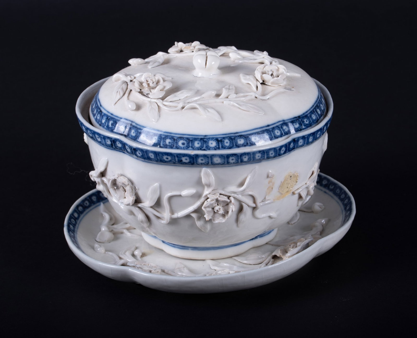 A Rare Chinese Qianlong Covered Quatrefoil Bowl with Stand: A Rare Chinese Qianlong Covered Quatrefoil Bowl with Stand China, early to mid 18th century, the lobed covered bowl having a white ground with dark blue floral border, applied flower decoration to the
