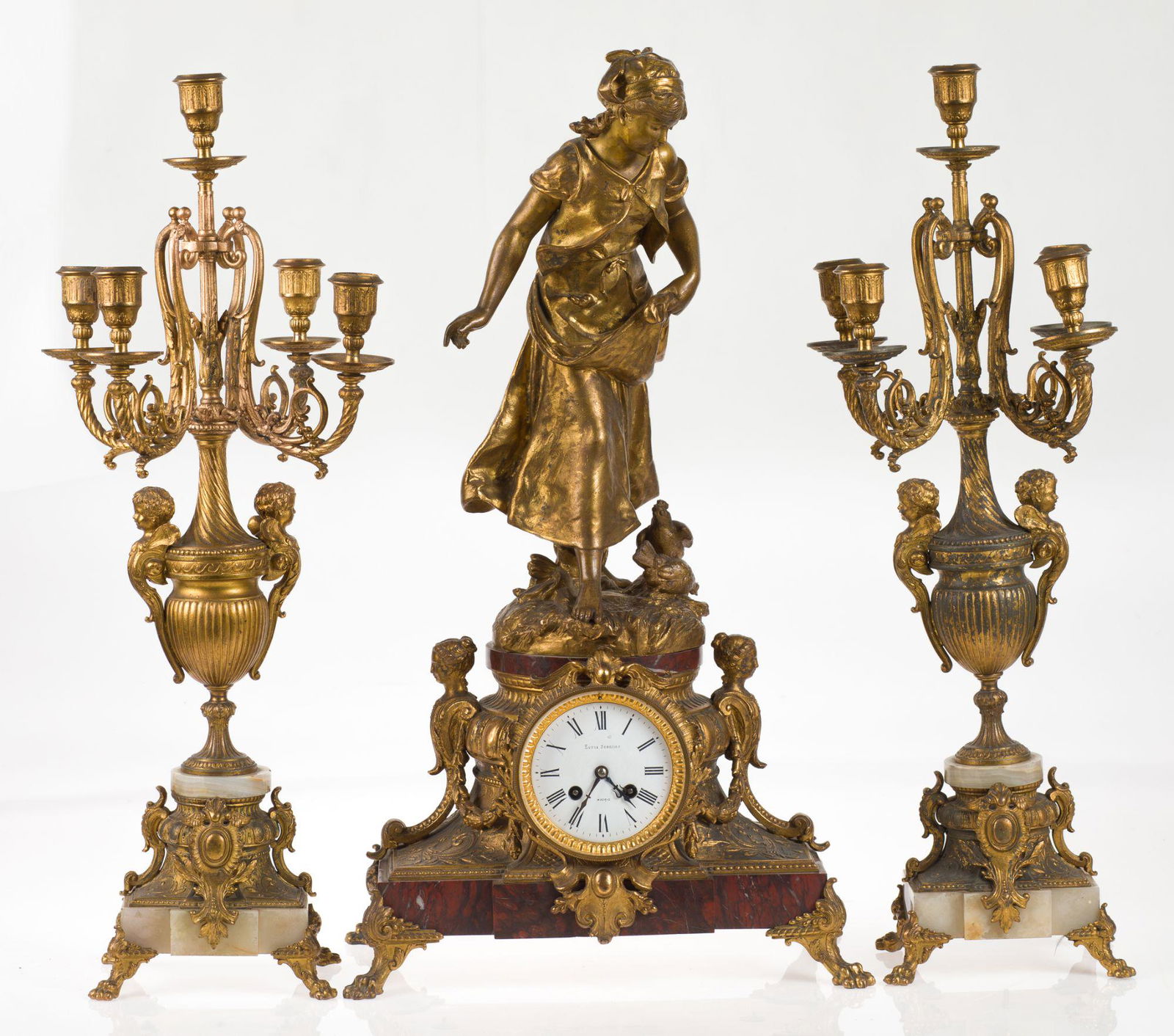 Clock and candlesticks, pps. S. XX. 66 and 63 cm high.: Lot of clock and pair of chandeliers pps 20th century in gilded metal, alabaster and marble. Clock with peasant's signatures, following Moreau's models, whose signature appears on the base. Measuremen